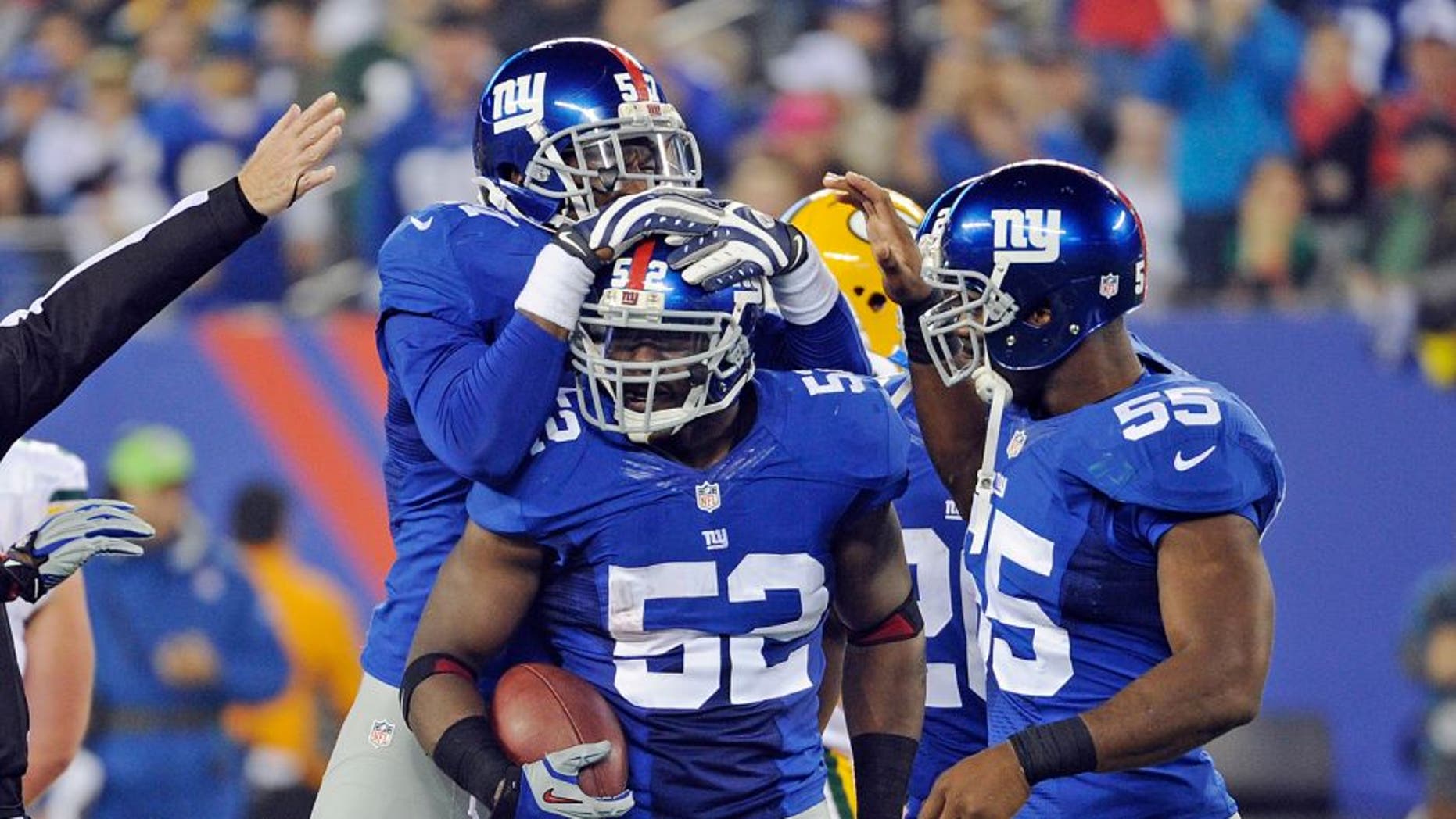 New York Giants' Jon Beason (52) celebrates with teammates Jacquian Williams, left, and Keith Rivers (55) after Beason got an interception during the second half of an NFL football game against the Green Bay Packers, Sunday, Nov. 17, 2013, in East Rutherford, N.J. (AP Photo/Bill Kostroun)
