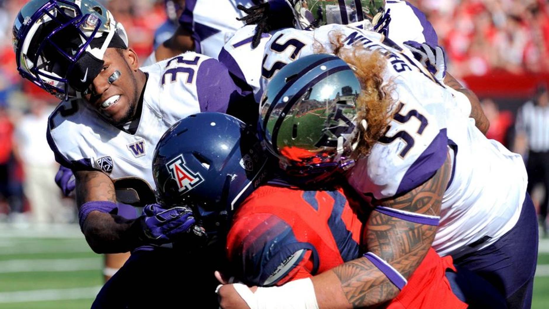 Nov 15, 2014; Tucson, AZ, USA; Washington Huskies defensive back Budda Baker (32) and defensive lineman Danny Shelton (55) tackle Arizona Wildcats running back Nick Wilson (28) during the first half at Arizona Stadium. Mandatory Credit: Casey Sapio-USA TODAY Sports