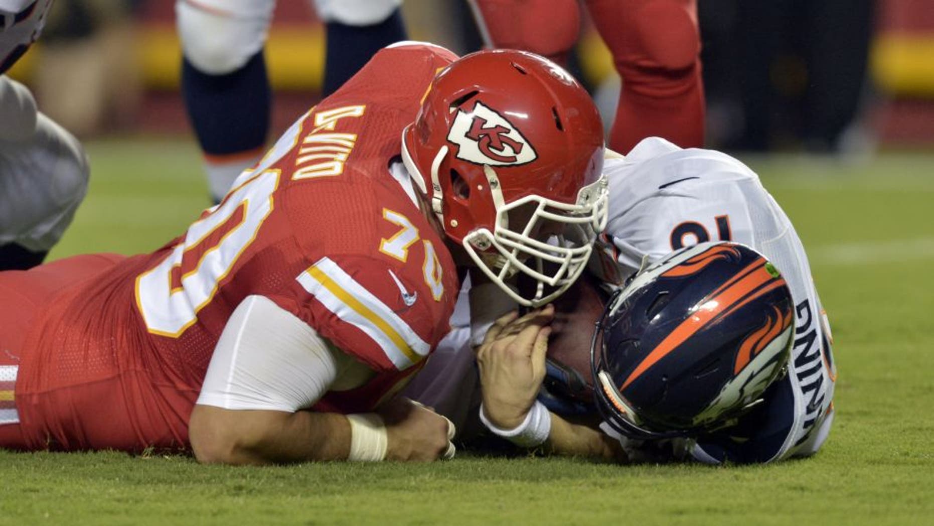 Sep 17, 2015; Kansas City, MO, USA; Denver Broncos quarterback Peyton Manning (18) is sacked by Kansas City Chiefs defensive end Mike DeVito (70) during the first half at Arrowhead Stadium. Mandatory Credit: Denny Medley-USA TODAY Sports