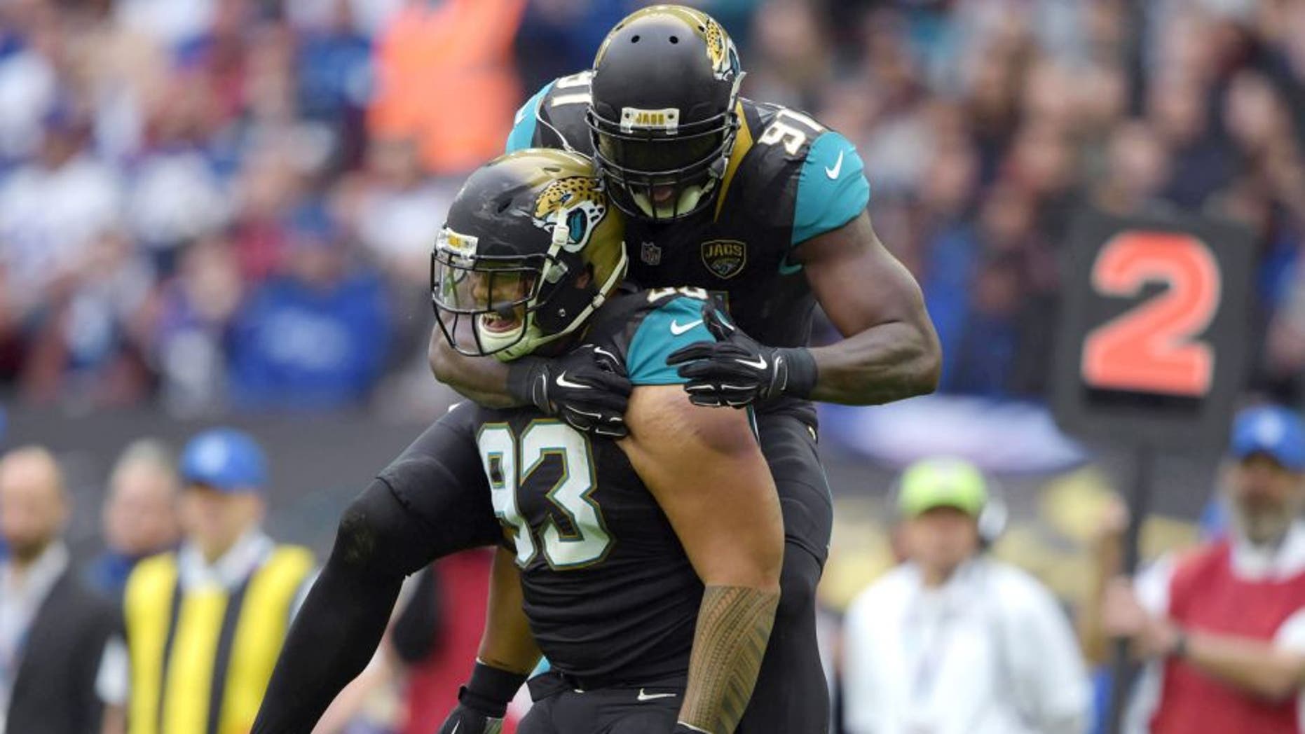 Oct 25, 2015; London, United Kingdom; Jacksonville Jaguars defensive end Tyson Alualu (93) celebrates with defensive end Chris Clemons (91) after a sack in the first quarter against the Buffalo Bills during NFL International Series game at Wembley Stadium. Mandatory Credit: Kirby Lee-USA TODAY Sports