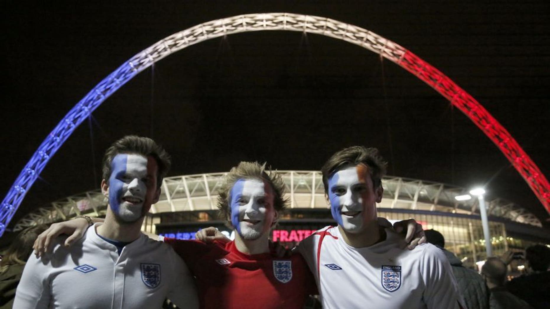 LONDON, ENGLAND - NOVEMBER 17: Football fans with their faces painted in the colors of Frenc flag are seen outside of Wembley Stadium, before the start of the friendly football match between England and France at Wembley Stadium in west London on November 17, 2015. (Photo by Yunus Kaymaz/Anadolu Agency/Getty Images)