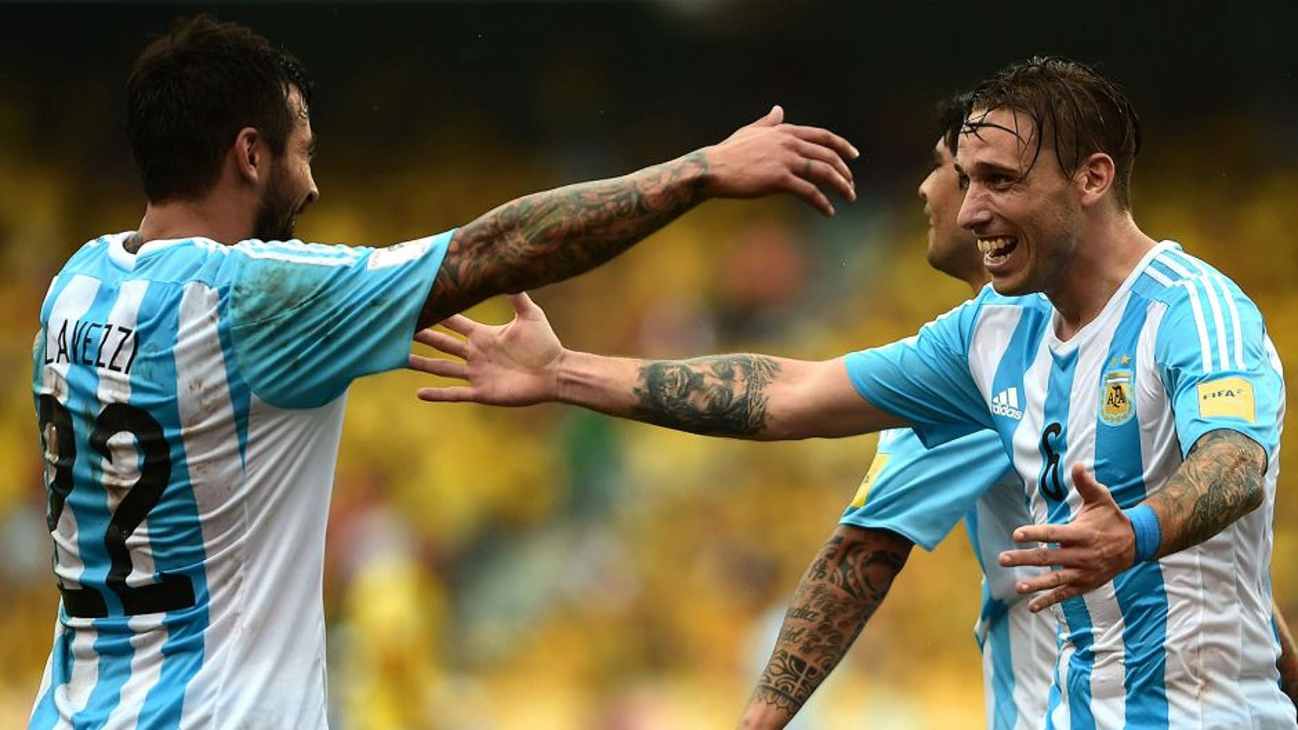 Argentina's Lucas Biglia (R) celebrates with Ezequiel Lavezzi after scoring against Colombia during their Russia 2018 FIFA World Cup South American Qualifiers football match, in Barranquilla on November 17, 2015. AFP PHOTO / LUIS ROBAYO (Photo credit should read LUIS ROBAYO/AFP/Getty Images)