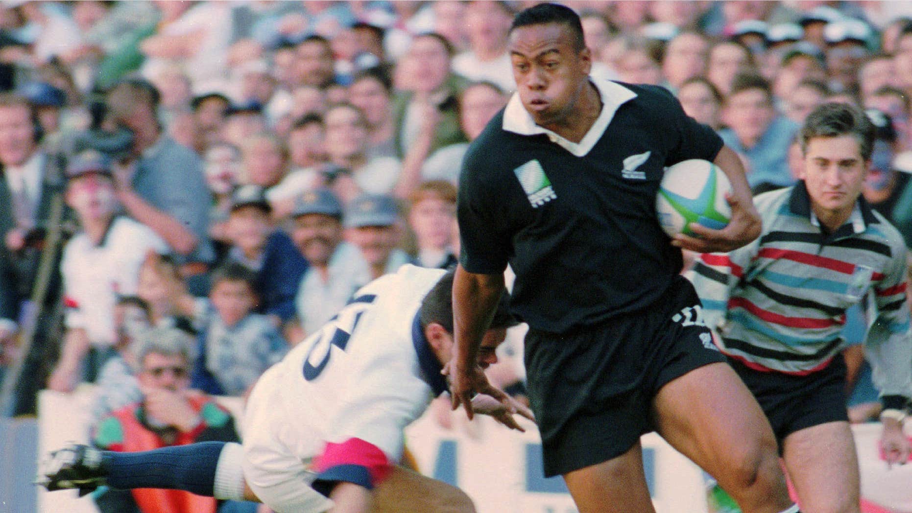 In this June 18, 1995 file photo, New Zealand All Blacks winger Jonah Lomu runs around England's Will Carling on his way to score the opening try in the Rugby World Cup semifinal at Newlands in Cape Town, South Africa.