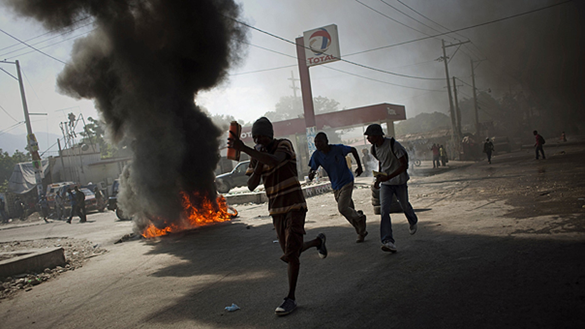 Nov. 18: Demonstrators run past burning tires during a protest in Port-au-Prince, Haiti. Protesters in Haiti's capital clashed with police following days of rioting in northern Haiti over suspicions that U.N. soldiers introduced a cholera epidemic that has killed more than 1,000 people.