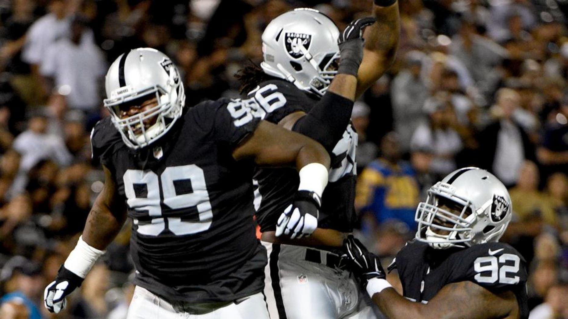 August 14, 2015; Oakland, CA, USA; Oakland Raiders defensive tackle Leon Orr (99), defensive end Denico Autry (96), and defensive tackle Stacy McGee (92) celebrate during the fourth quarter in a preseason NFL football game against the St. Louis Rams at O.co Coliseum. The Raiders defeated the Rams 18-3. Mandatory Credit: Kyle Terada-USA TODAY Sports