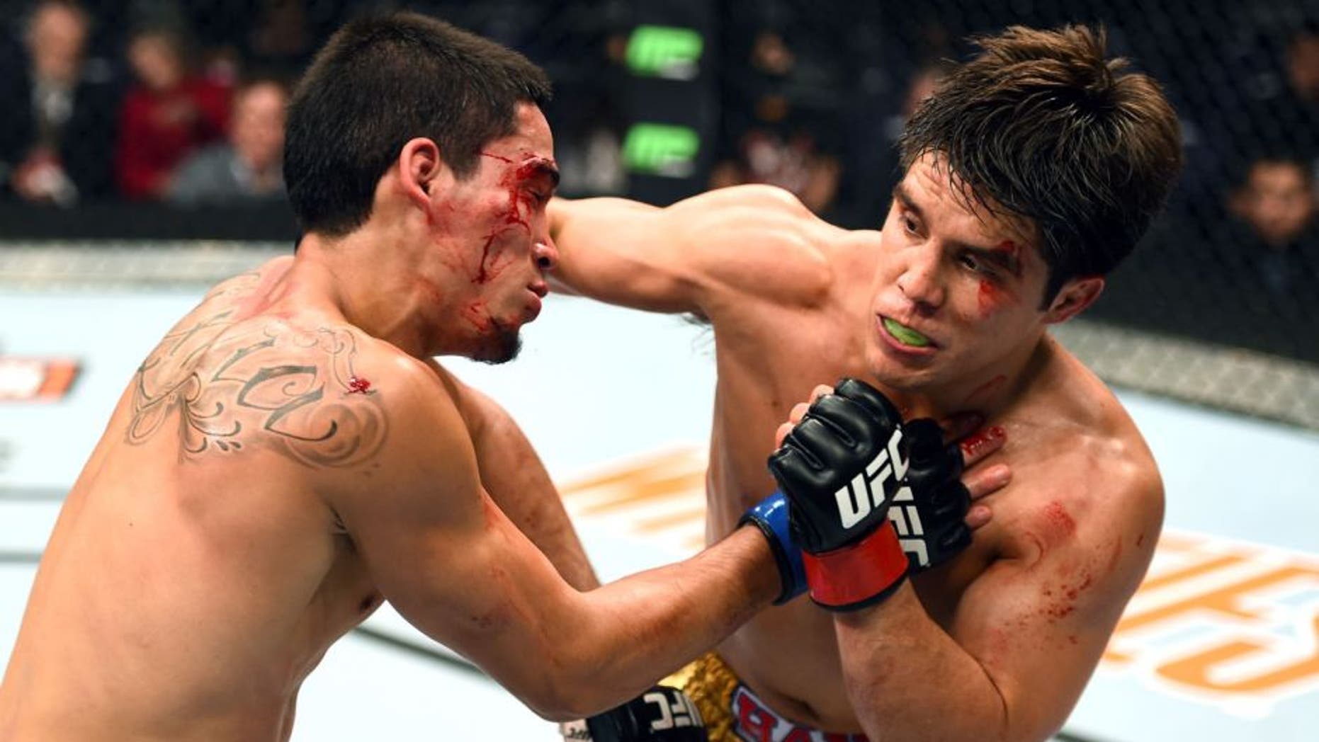 PHOENIX, AZ - DECEMBER 13: (R-L) Henry Cejudo punches Dustin Kimura in their bantamweight fight during the UFC Fight Night event at the U.S. Airways Center on December 13, 2014 in Phoenix, Arizona. (Photo by Josh Hedges/Zuffa LLC/Zuffa LLC via Getty Images)