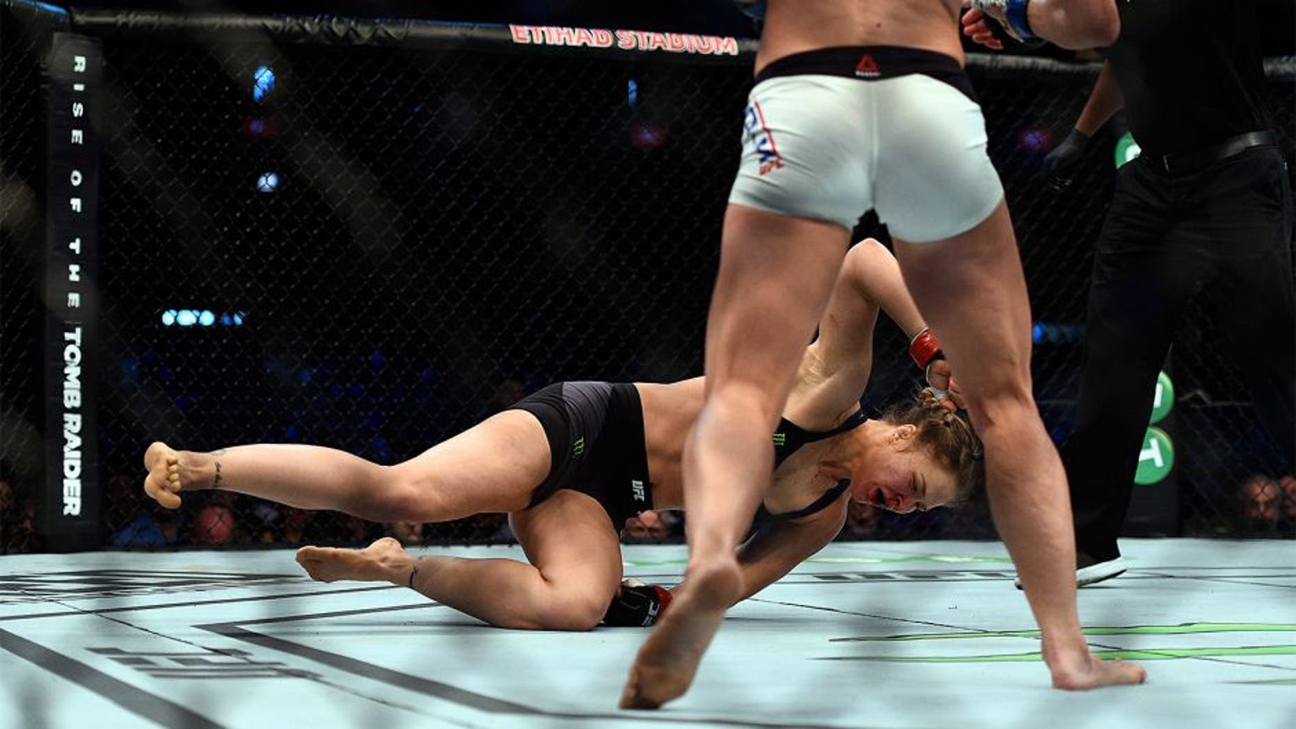 MELBOURNE, AUSTRALIA - NOVEMBER 15: (L-R) Ronda Rousey falls to the mat as she is knocked out by Holly Holm in their UFC women's bantamweight championship bout during the UFC 193 event at Etihad Stadium on November 15, 2015 in Melbourne, Australia. (Photo by Jeff Bottari/Zuffa LLC/Zuffa LLC via Getty Images)