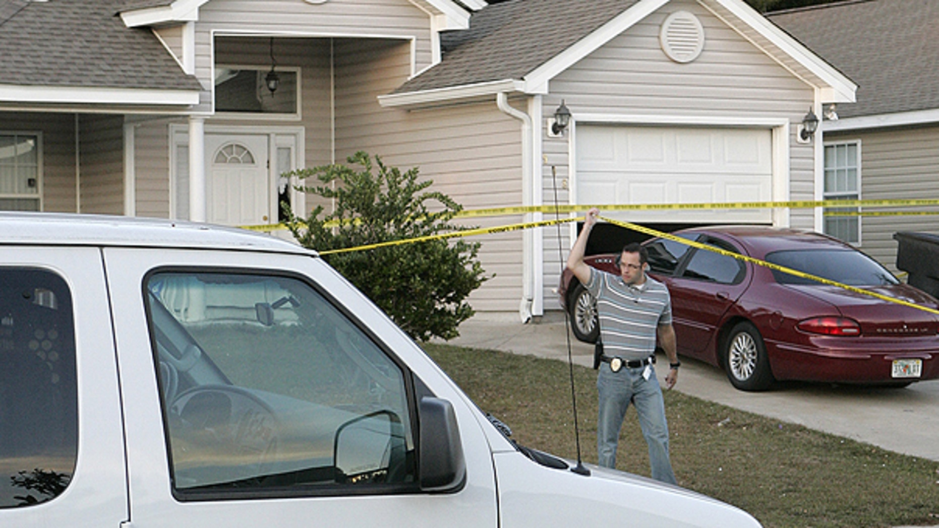 Nov. 20: An investigator lifts police tape to pass under at a home where a woman and three children were slain in Tallahassee, Fla.