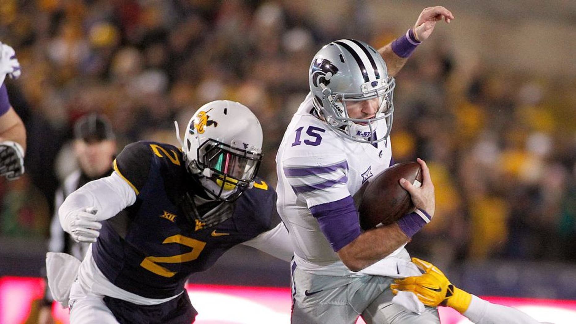 MORGANTOWN, WV - NOVEMBER 20: Jake Waters #15 of the Kansas State Wildcats rushes against Brandon Golson #2 and Karl Joseph #8 of the West Virginia Mountaineers in the second quarter during the game on November 20, 2014 at Mountaineer Field in Morgantown, West Virginia. (Photo by Justin K. Aller/Getty Images)