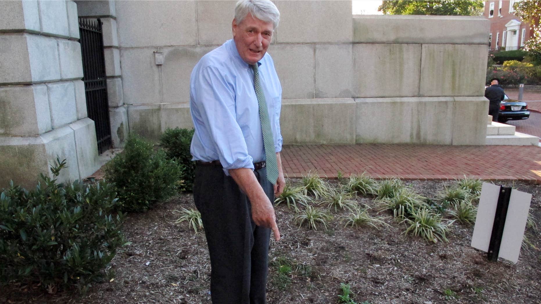 Nov. 20, 2015: Maryland House Speaker Michael Busch points to a weed on the grounds of the Maryland State House in Annapolis, Md.
