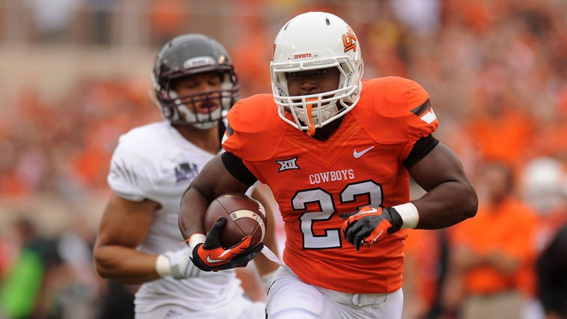 Sep 6, 2014; Stillwater, OK, USA; Oklahoma State Cowboys running back Rennie Childs (23) runs the ball against the Missouri State Bears during the first quarter at Boone Pickens Stadium. Mandatory Credit: Mark D. Smith-USA TODAY Sports