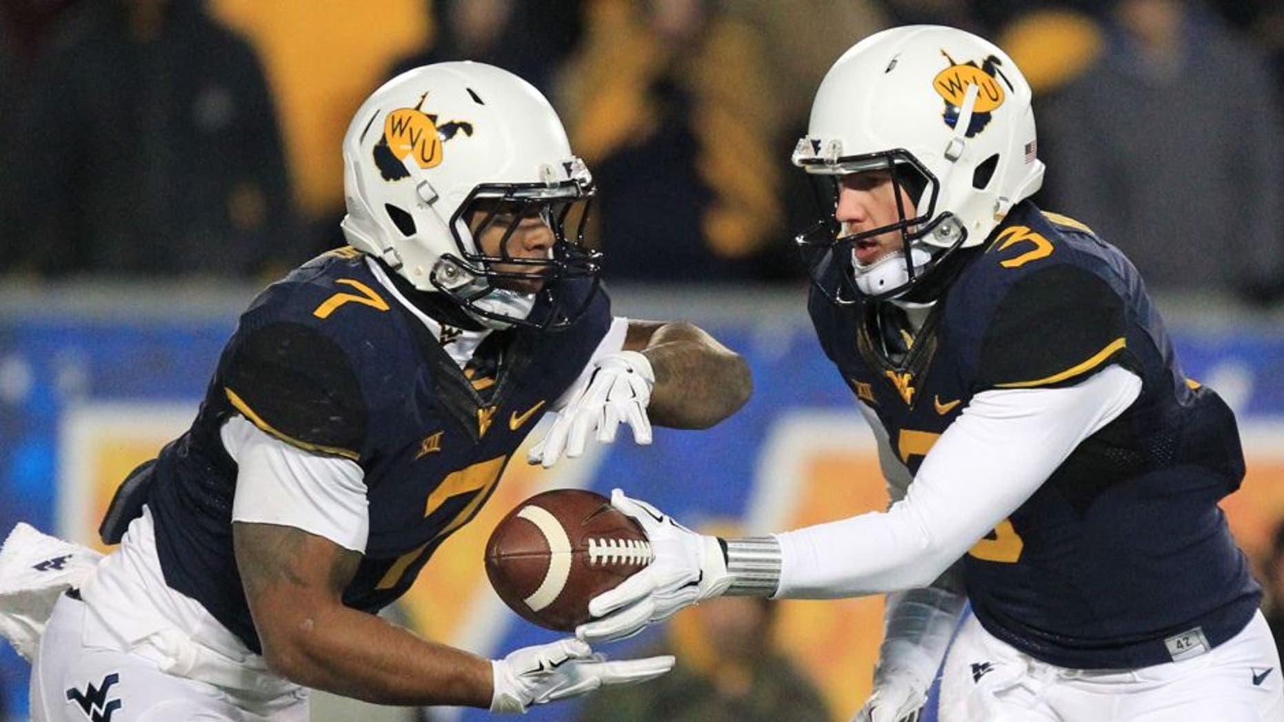 West Virginia quarterback Skyler Howard (3) hands the ball off to Rushel Shell (7) during the second half of an NCAA college football game against Kansas State in Morgantown, W.Va., on Thursday, Nov. 20, 2014. Kansas State won 26-20. (AP Photo/Chris Jackson)