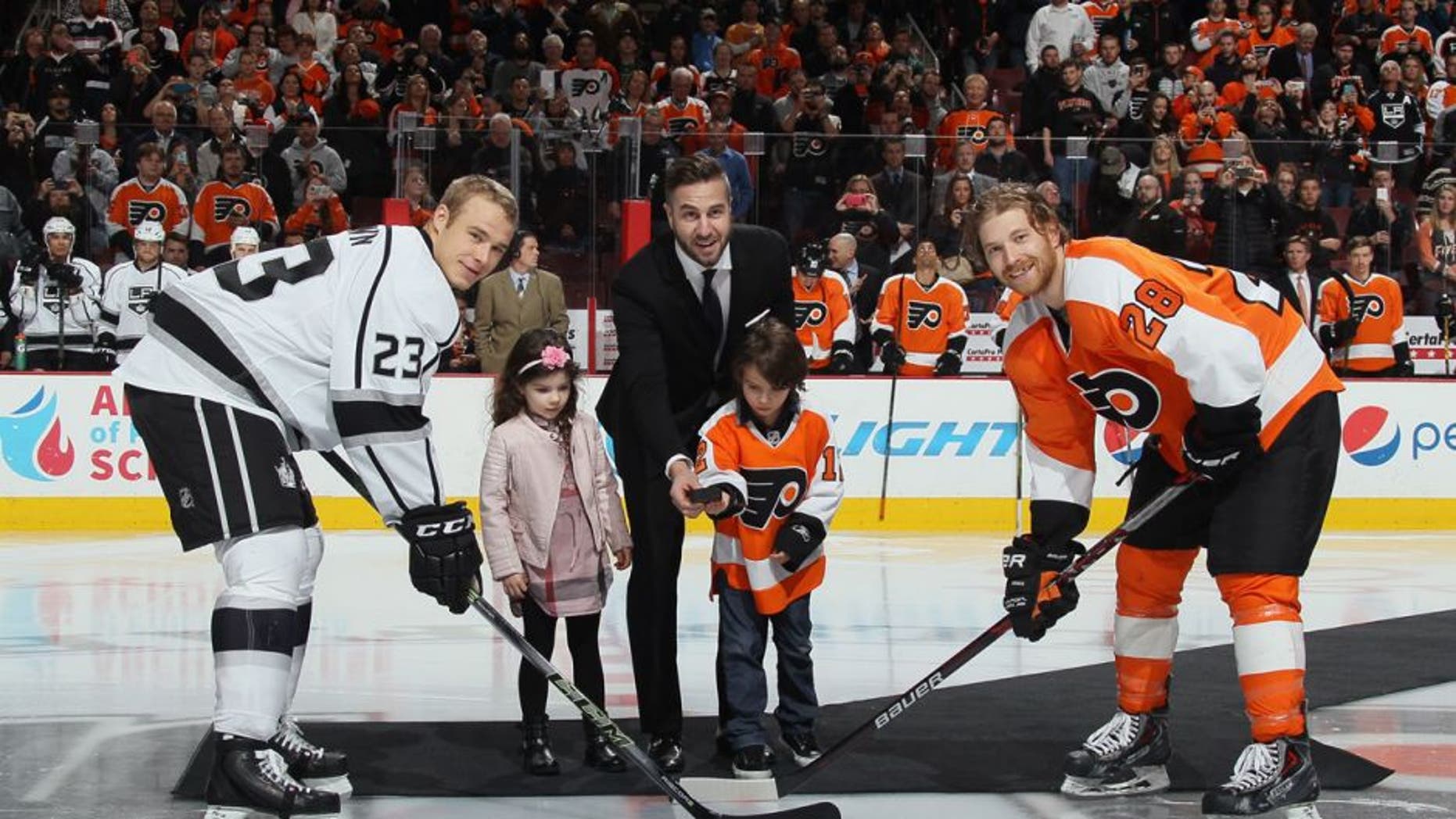 PHILADELPHIA, PA - NOVEMBER 17: Former player Simon Gagne is honored prior to the game between the Philadelphia Flyers and the Los Angeles Kings and drops the puck between Dustin Brown #23 and Claude Giroux #28 at the Wells Fargo Center on November 17, 2015 in Philadelphia, Pennsylvania. (Photo by Bruce Bennett/Getty Images)
