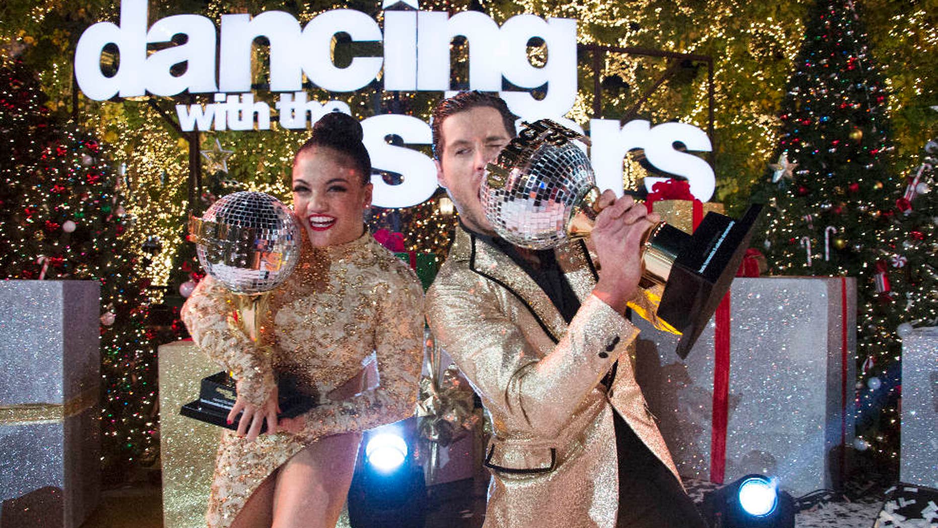 In this Nov. 22, 2016 photo released by ABC, Laurie Hernandez, left, and Val Chmerkovskiy celebrate after winning the 23rd season of the celebrity dance competition series, "Dancing With The Stars," in Los Angeles.