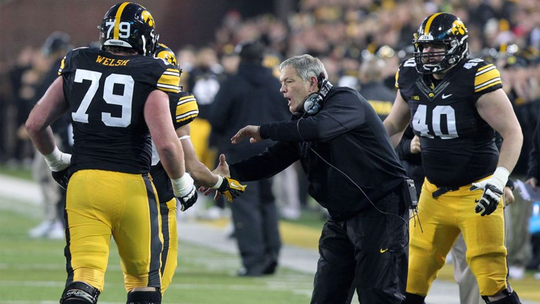 Nov 22, 2014; Iowa City, IA, USA; Iowa Hawkeyes head coach Kirk Ferentz celebrates with offensive lineman Sean Welsh (79) after the Hawks scored a touchdown against the Wisconsin Badgers at Kinnick Stadium. Wisconsin beat Iowa 26-24. Mandatory Credit: Reese Strickland-USA TODAY Sports