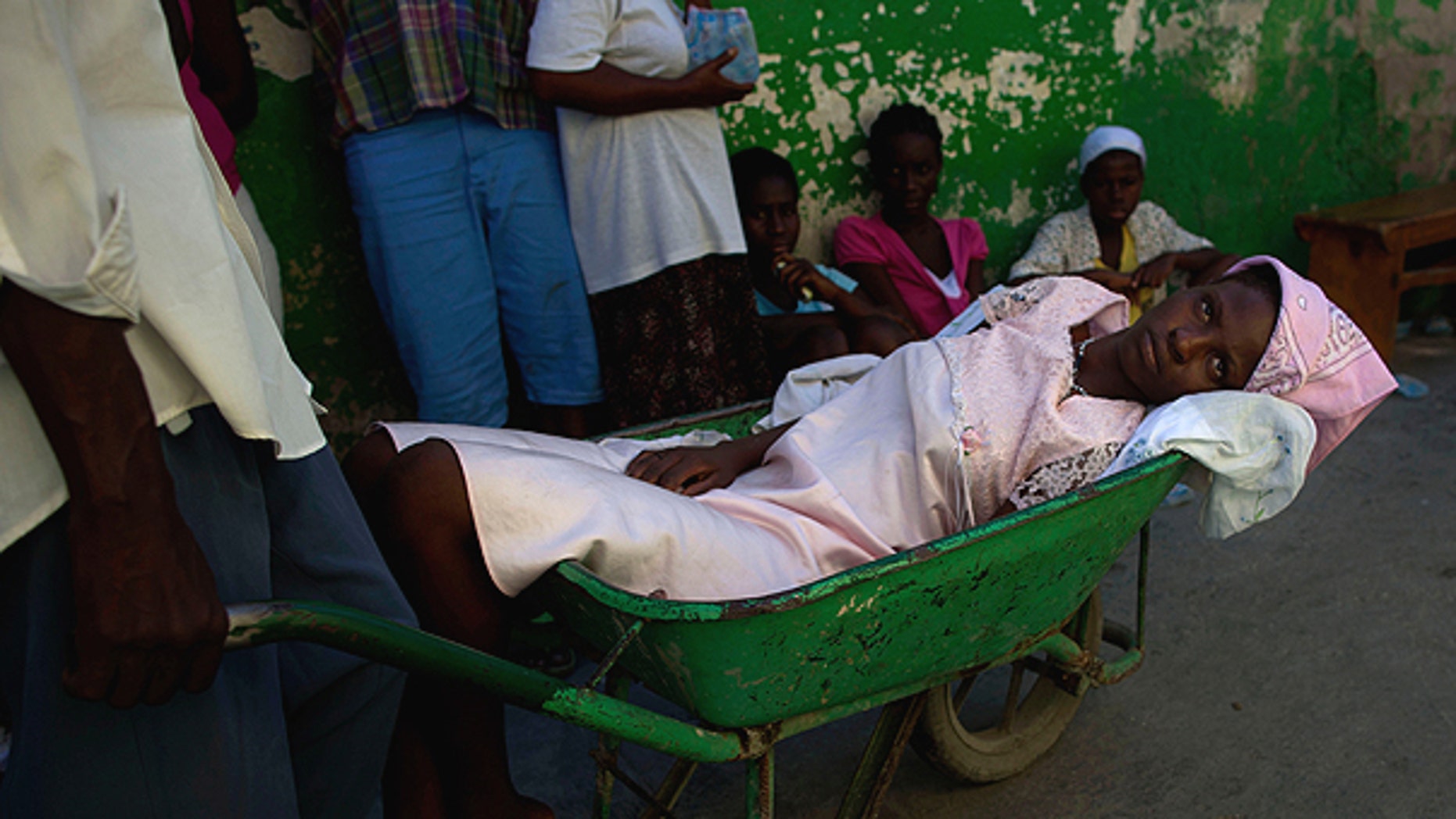 Nov. 17: A woman suffering cholera symptoms is pushed in a wheelbarrow to St. Catherine hospital, run by Doctors Without Borders, in the slum of Cite Soleil in Port-au-Prince, Haiti.