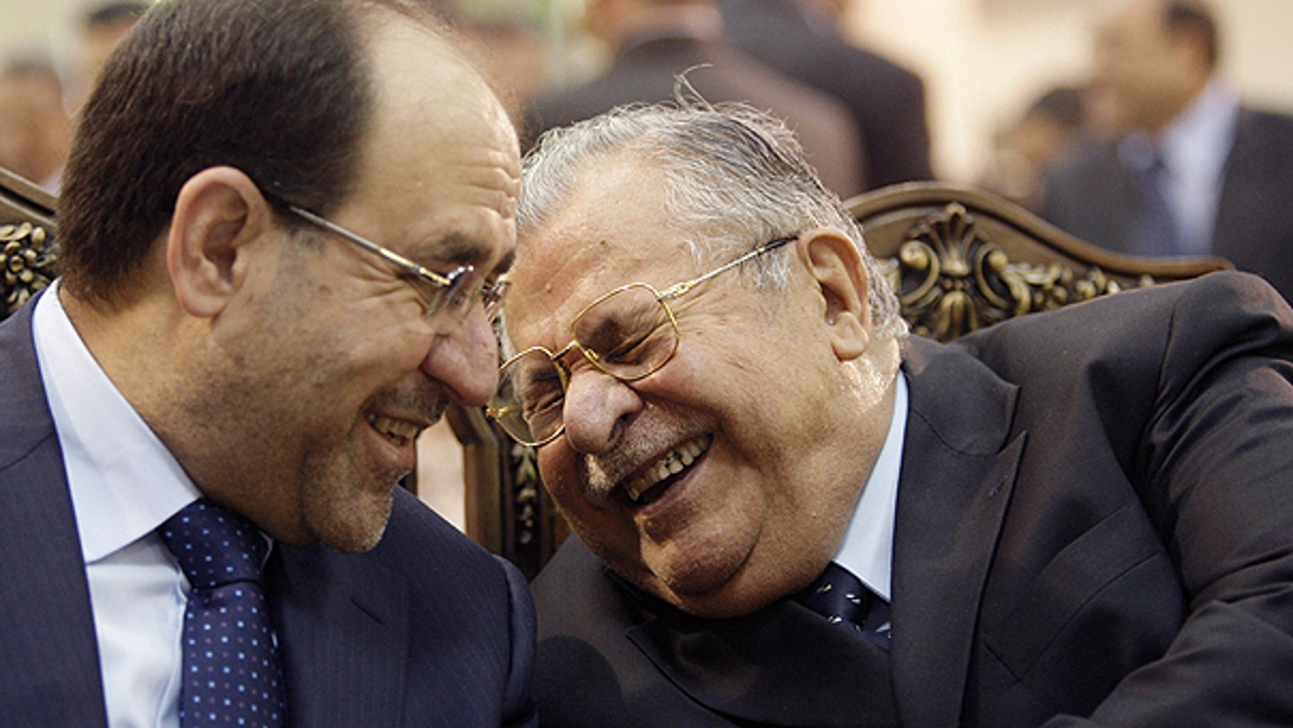 In this June. 27, 2009 file photo, Iraq's Prime Minister Nouri al-Maliki, left, and President Jalal Talabani, right, react, at a ceremony marking the 2003 death of Mohammed Baqir al-Hakim in Baghdad, Iraq.
