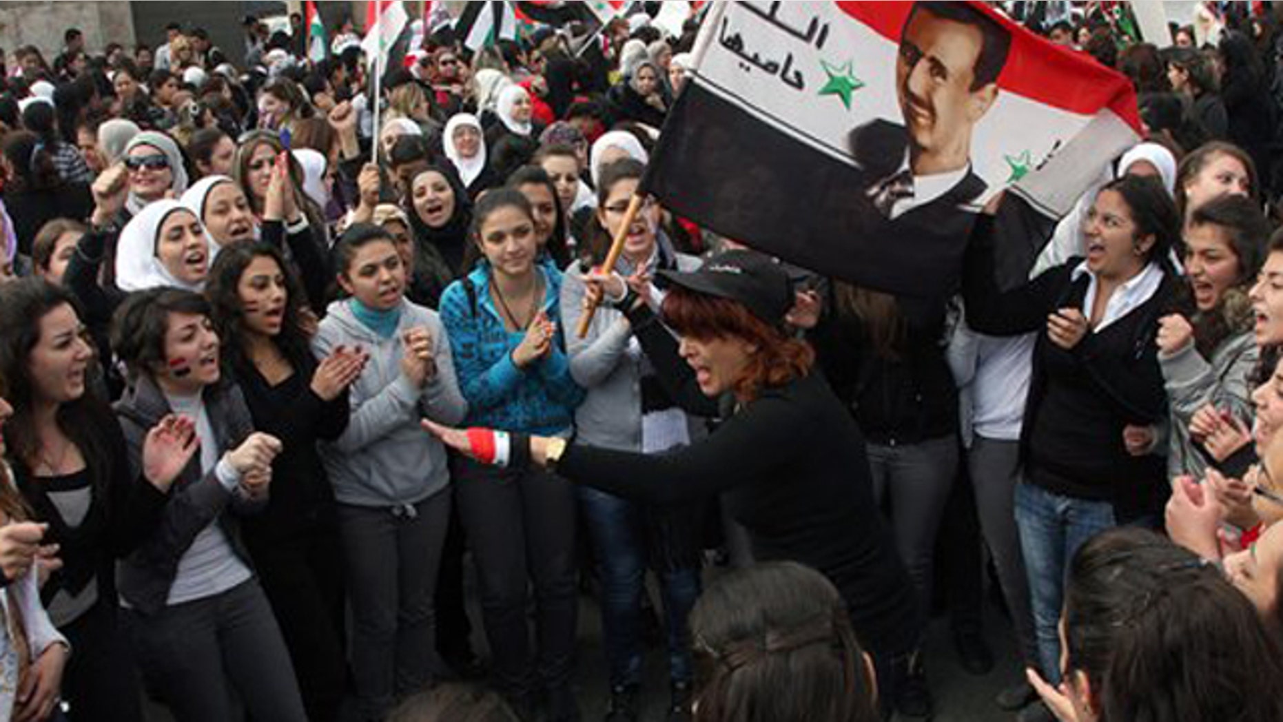 November 24, 2011: Pro-Syrian regime protesters shout pro-Syrian President Bashar Assad slogans during a protest against the Arab League meeting, in Damascus, Syria.