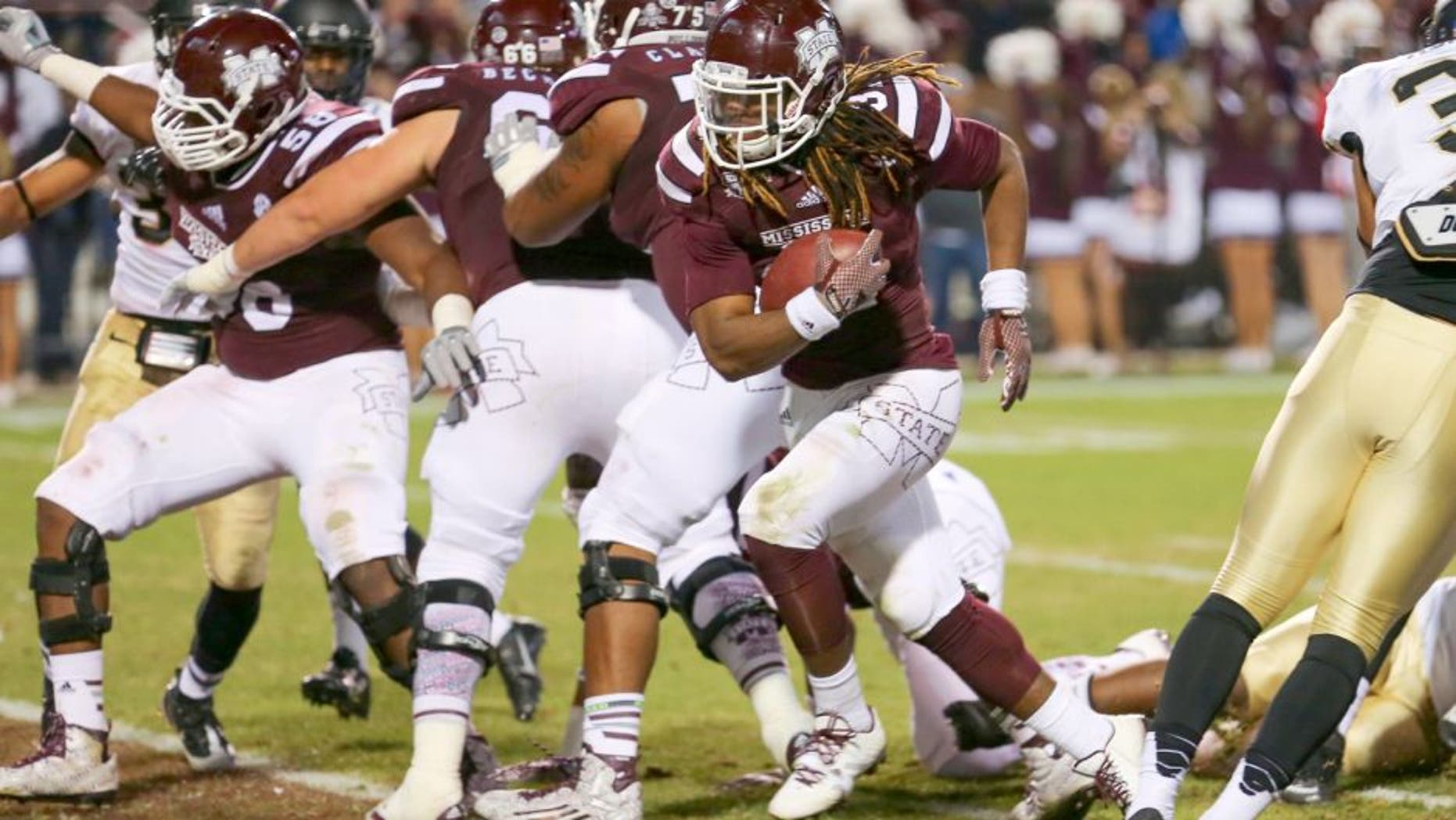 Nov 22, 2014; Starkville, MS, USA; Mississippi State Bulldogs running back Ashton Shumpert (32) carries the ball in for a touchdown during the game against the Vanderbilt Commodores at Davis Wade Stadium. Mandatory Credit: Spruce Derden-USA TODAY Sports