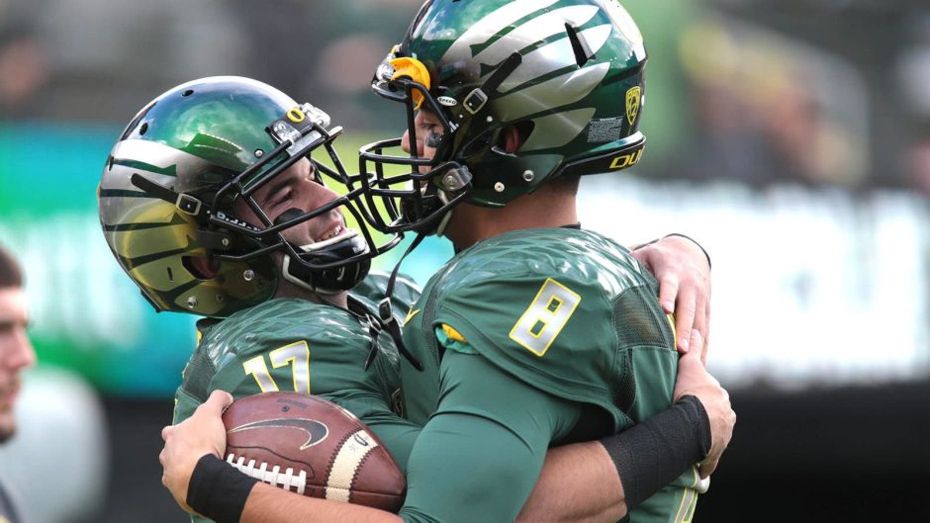 Nov 22, 2014; Eugene, OR, USA; Oregon Ducks quarterback Marcus Mariota (8) and quarterback Jeff Lockie (17) talk before the game against the Colorado Buffaloes at Autzen Stadium. Mandatory Credit: Scott Olmos-USA TODAY Sports