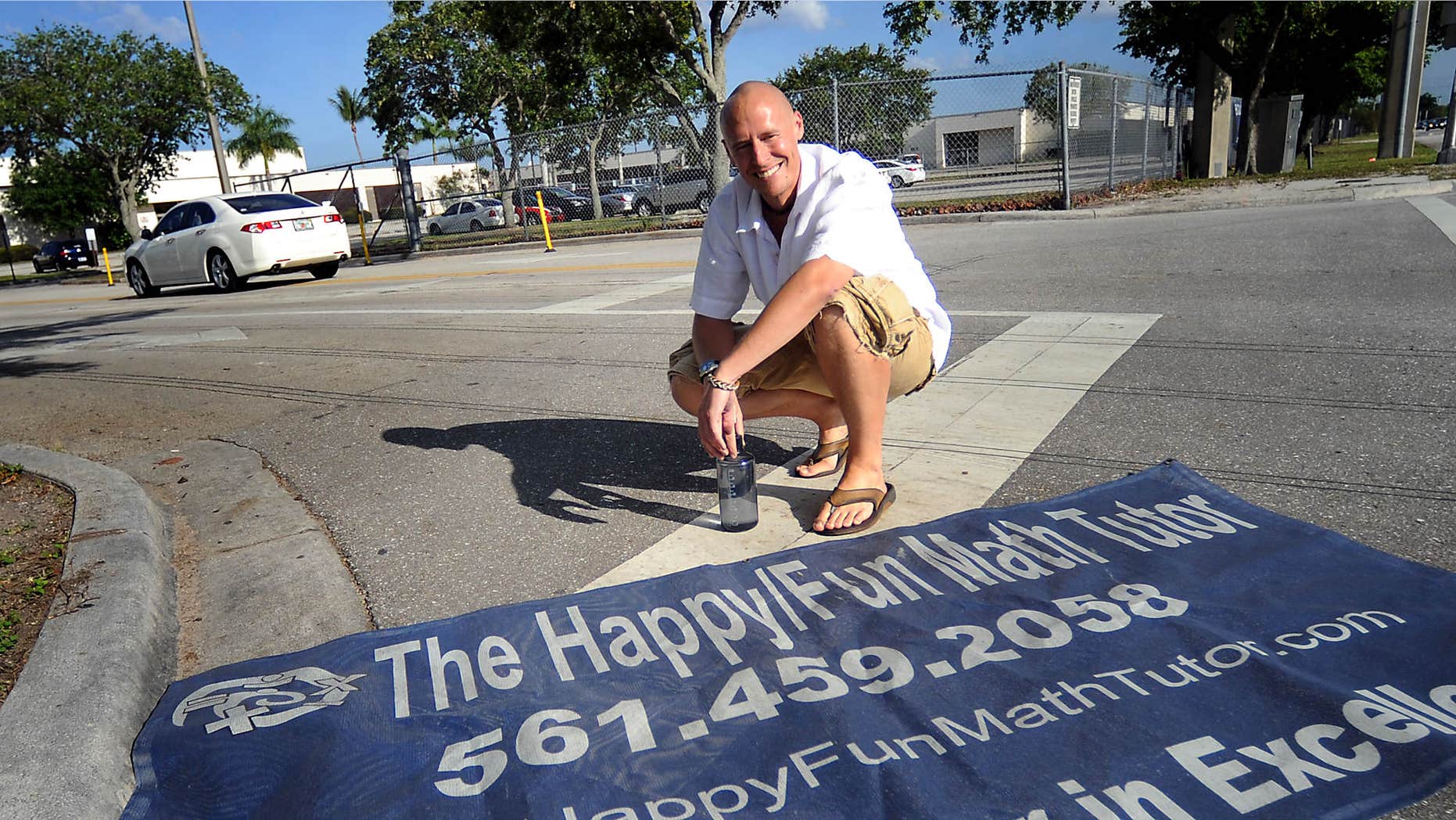 In this 2013 photo, Dave Mech displays his sign that was taken down by three Boca Raton schools after a parent of a student looked into Mech's past and found that one of his companies was affiliated with adult entertainment.