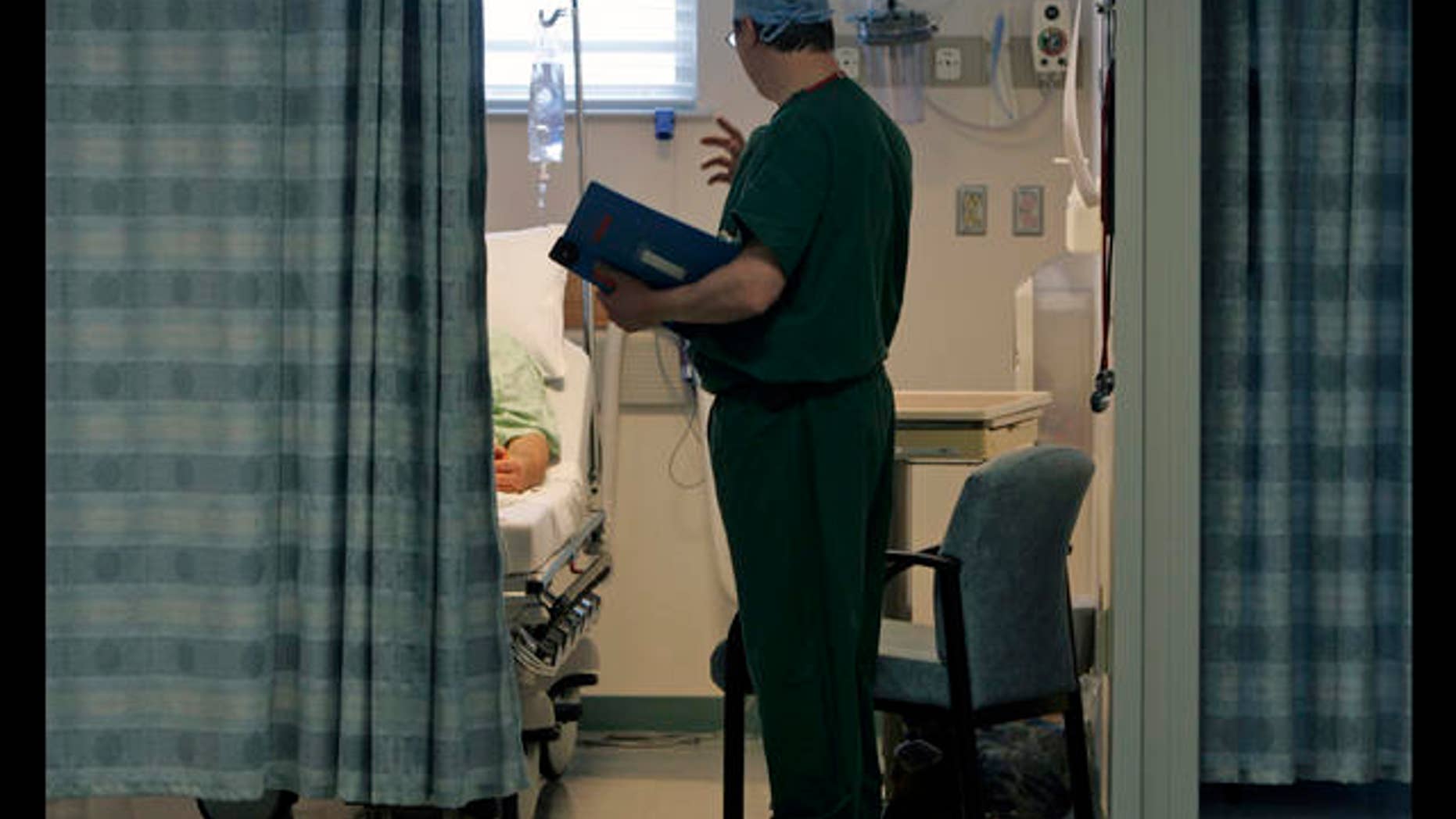 ** TO GO WITH STORY MEDICOS PRESTAMOS ** Dr. Gregory Zale visits a patient at Adirondack Medical Center in Saranac Lake, N.Y., Wednesday, Jan. 30, 2008. Hours from a big city, and a helicopter ride away from certain specialized medical treatments, Adirondack Medical Center is one of New York's medical outposts, struggling to compete with large metropolitan teaching hospitals when it comes to hiring physicians. (AP Photo/Mike Groll)