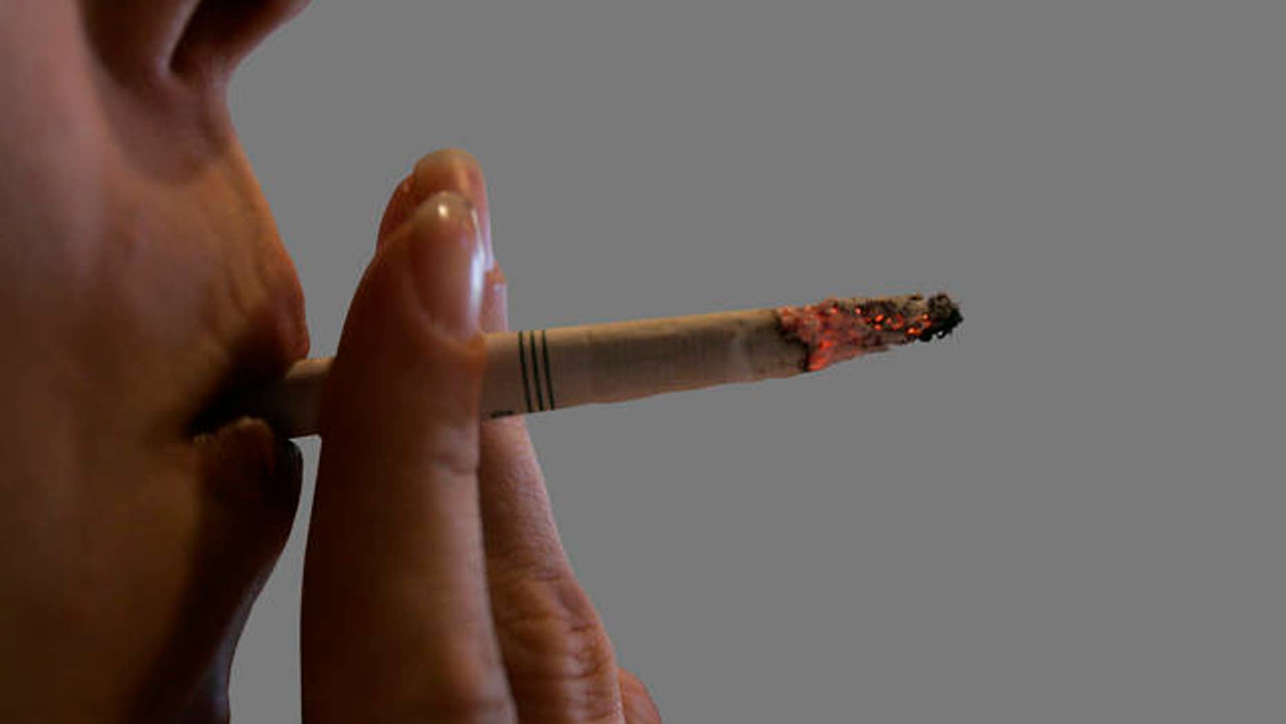 ** ADVANCE FOR MONDAY, MARCH 30 AND THEREAFTER -- FILE ** In this June 3, 2008 file photo, an employee takes a drag on a cigarette at Morgan's Place bar and restaurant in Harrisburg, Pa. Whether they satisfy their nicotine cravings with cigarettes, a pipe, cigars or smokeless, tobacco users are facing a big hit this week as the single largest federal tobacco tax hike in history takes effect next week. (AP Photo/Carolyn Kaster, File)