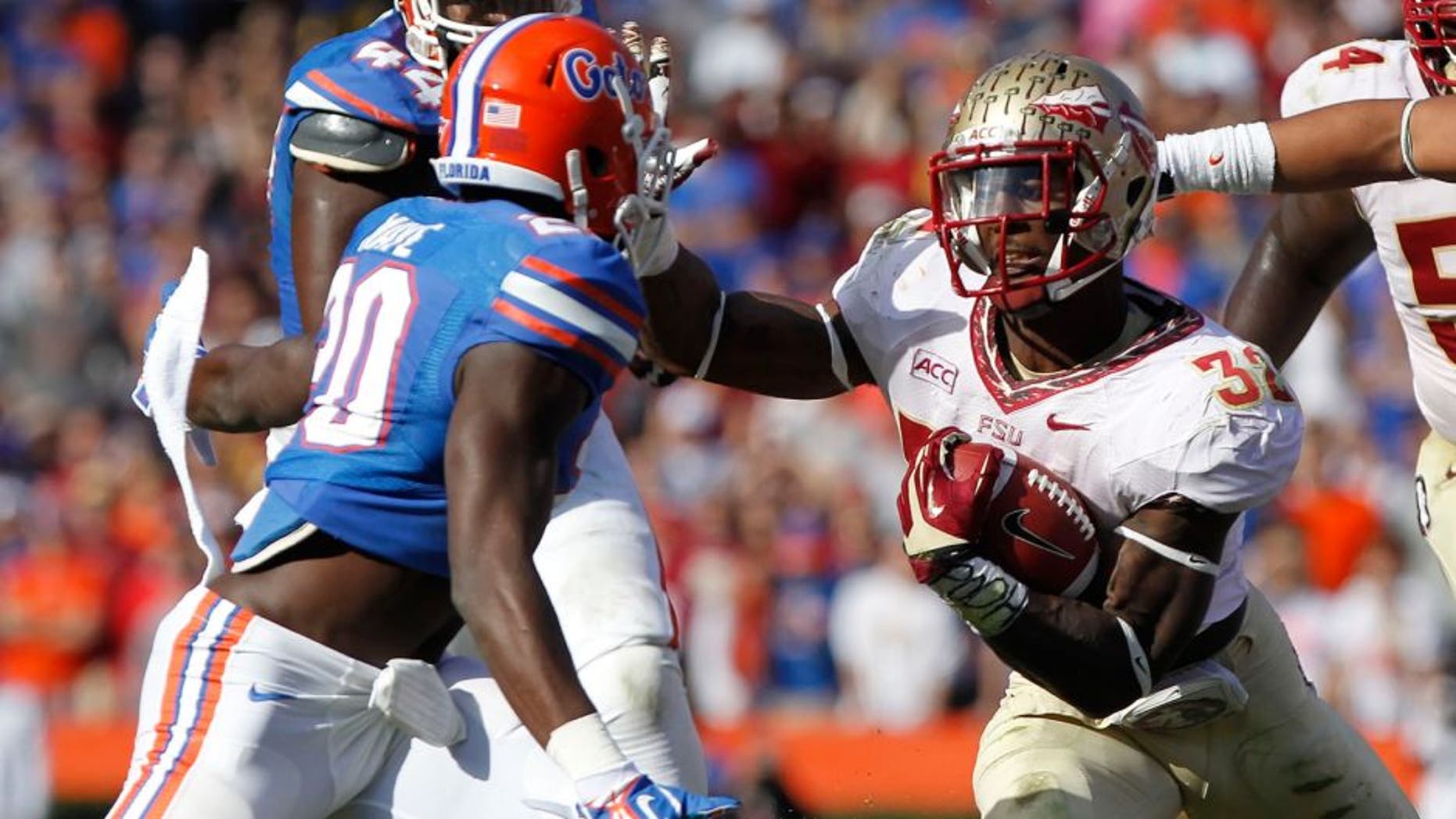 Nov 30, 2013; Gainesville, FL, USA; Florida State Seminoles running back James Wilder Jr. (32) runs with the ball as Florida Gators defensive back Marcus Maye (20) defends during the second half at Ben Hill Griffin Stadium. Florida State Seminoles defeated the Florida Gators 37-7. Mandatory Credit: Kim Klement-USA TODAY Sports