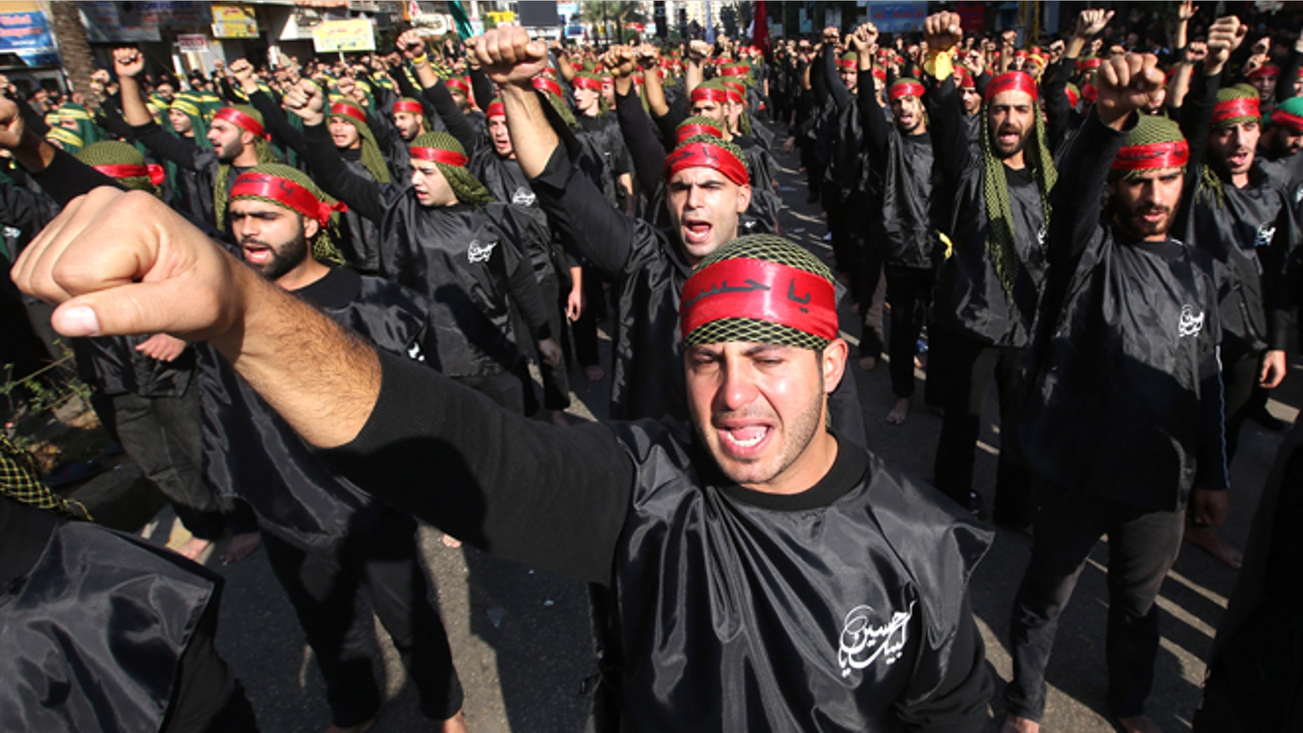 FILE -- Nov. 25, 2012: Shiite Muslim supporters of the Hezbollah, raise their fists as they chant slogans in support of pro-Hezbollah leader Sheik Hassan Nasrallah during a march to mark Ashoura Day, in the southern suburb of Beirut, Lebanon.