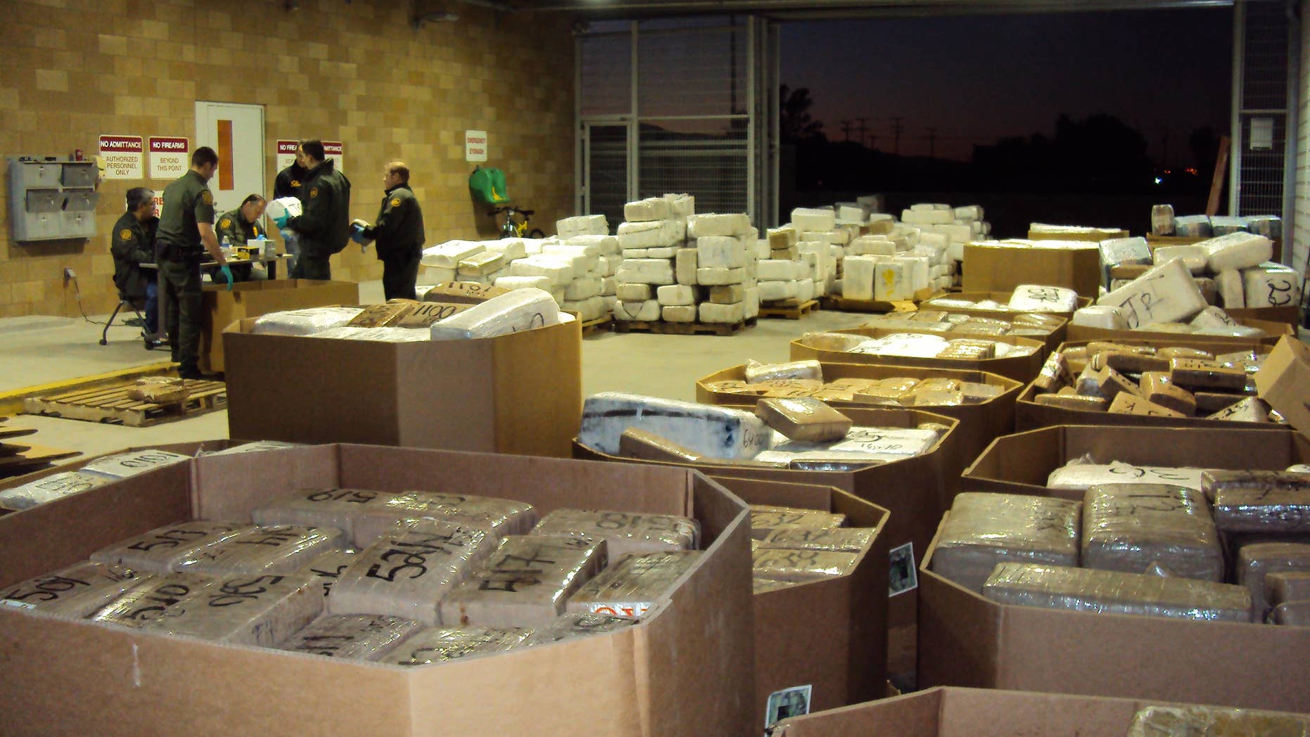 In this Nov. 25, 2010 photo released by U.S. Immigration and Customs Enforcement (ICE), packages of seized marijuana are examined by officials in Murrieta, Calif., after a cross-border tunnel between Tijuana, Mexico and San Diego was discovered.