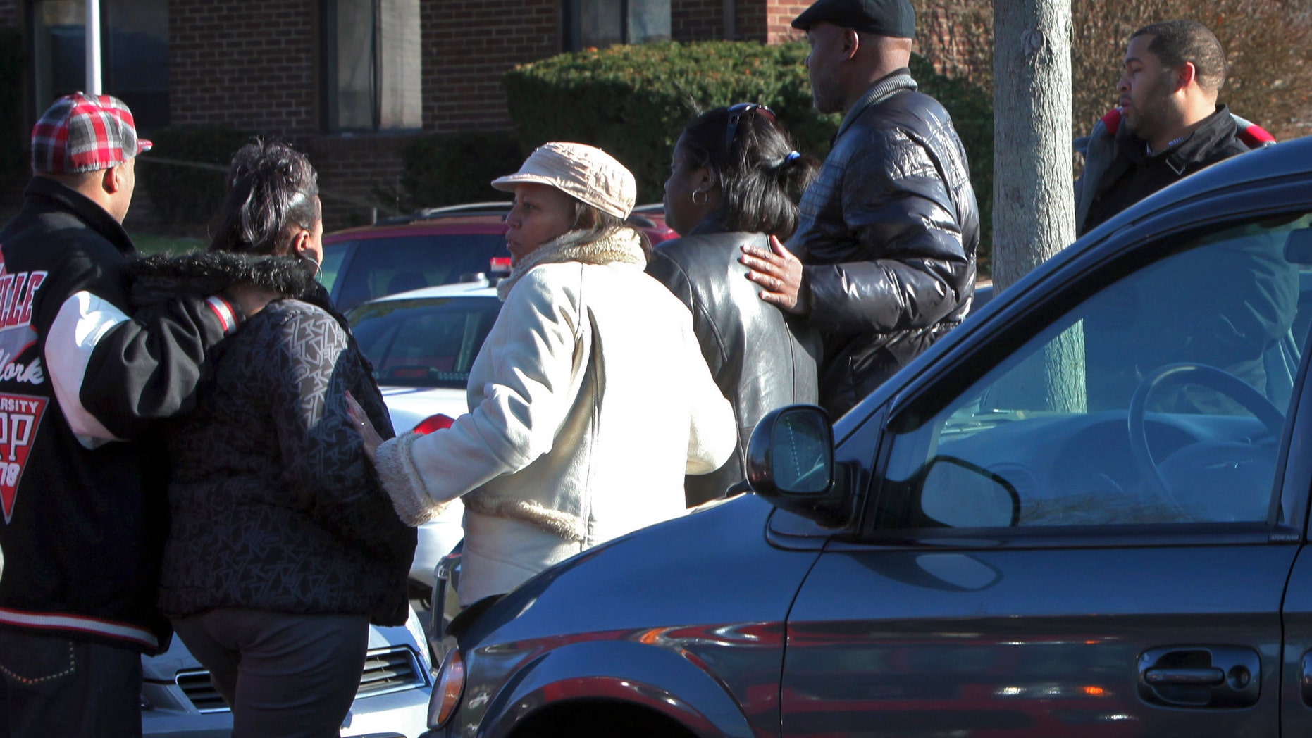 Nov. 26: Friends and co-workers of a woman involved in a triple homicide gather in the parking lot of her apartment complex on the north side of Columbus, Ohio.