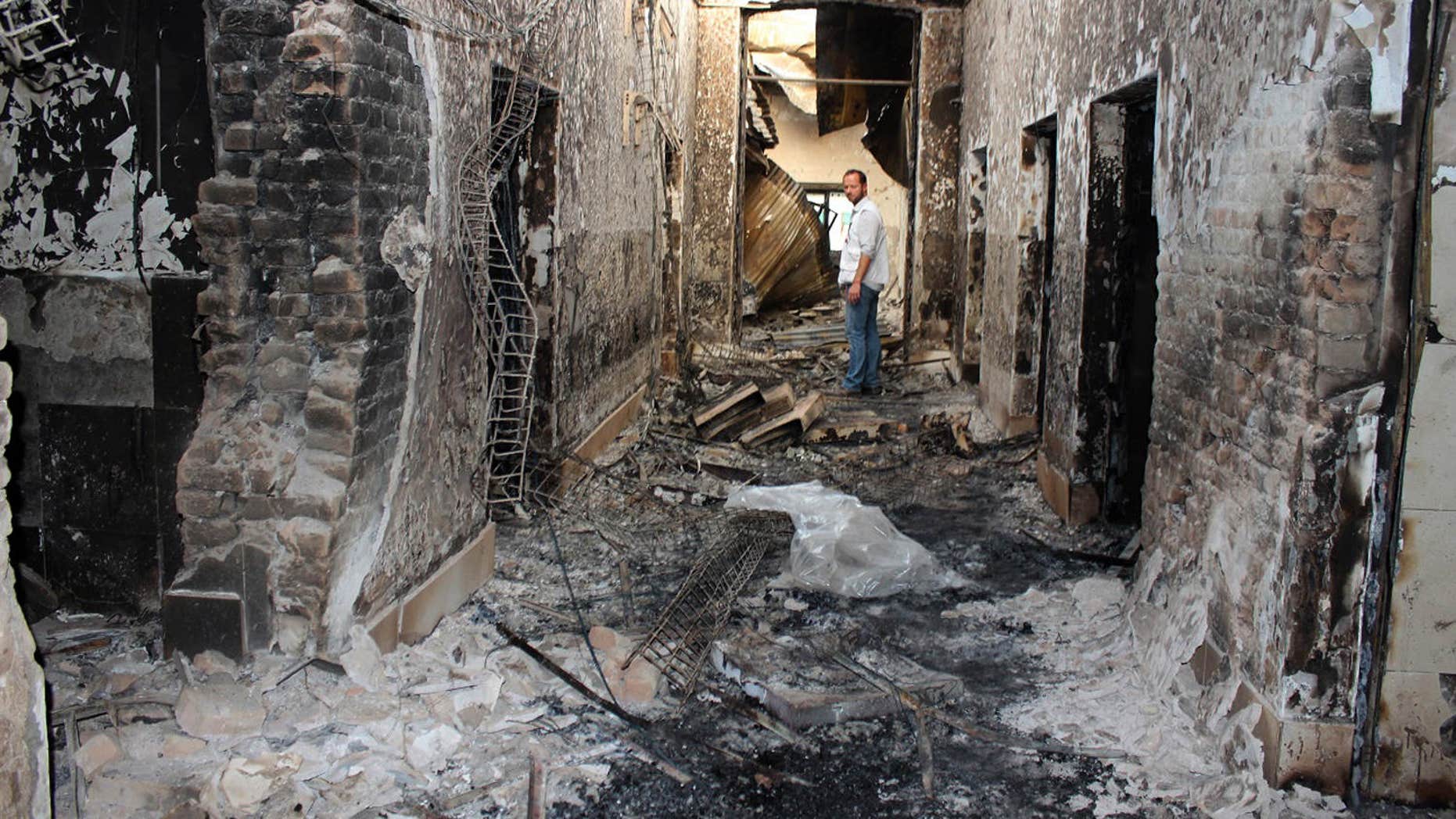 FILE - In this Oct. 16, 2015, file photo, an employee of Doctors Without Borders stands inside the charred remains of their hospital after it was hit by a U.S. airstrike in Kunduz, Afghanistan.