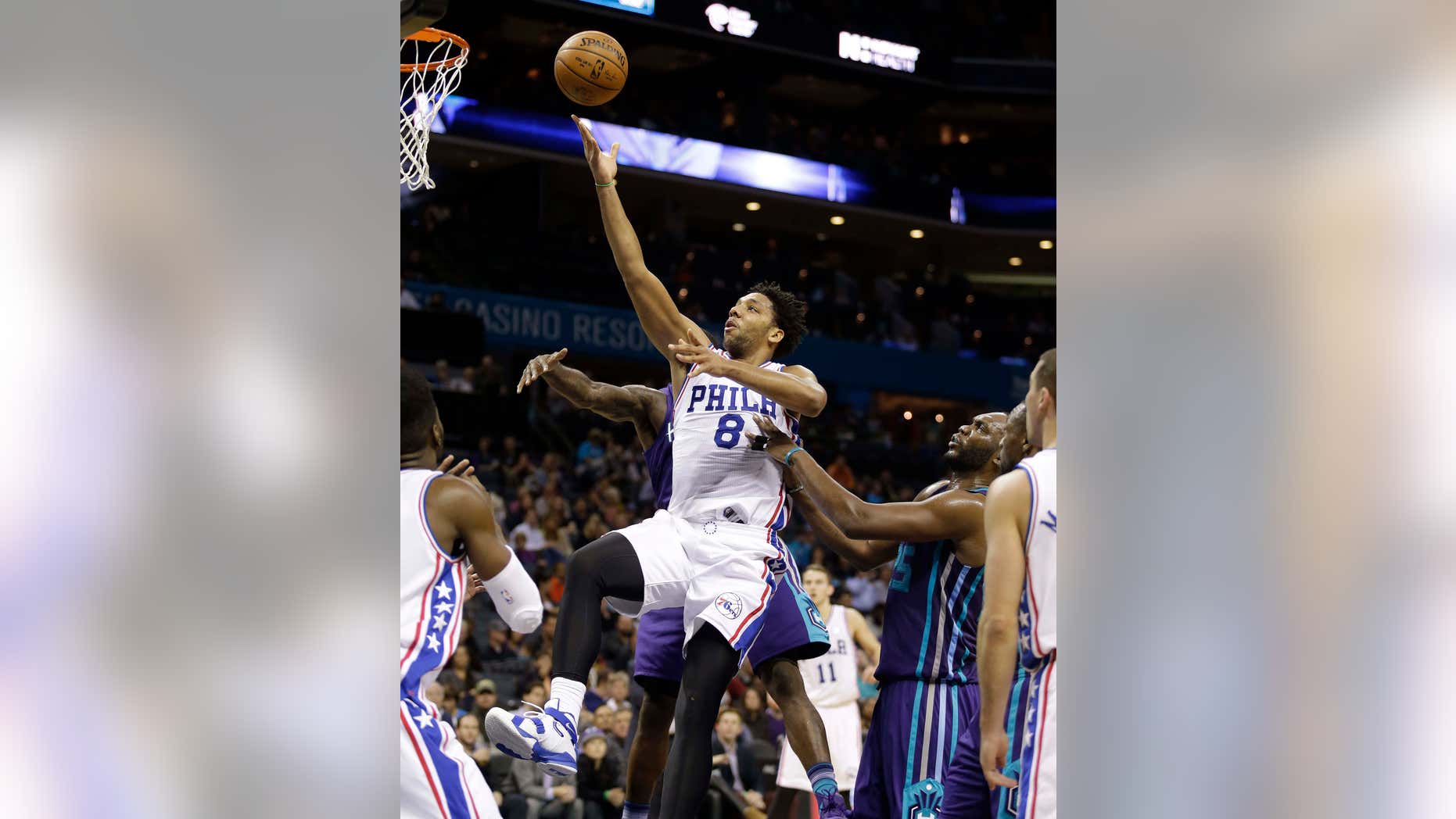 FILE - In this photo taken on Nov. 20, 2015, Philadelphia 76ers' Jahlil Okafor (8) slips through the lane and past a host of Charlotte Hornets as he scores in the second half of an NBA basketball game in Charlotte, N.C.