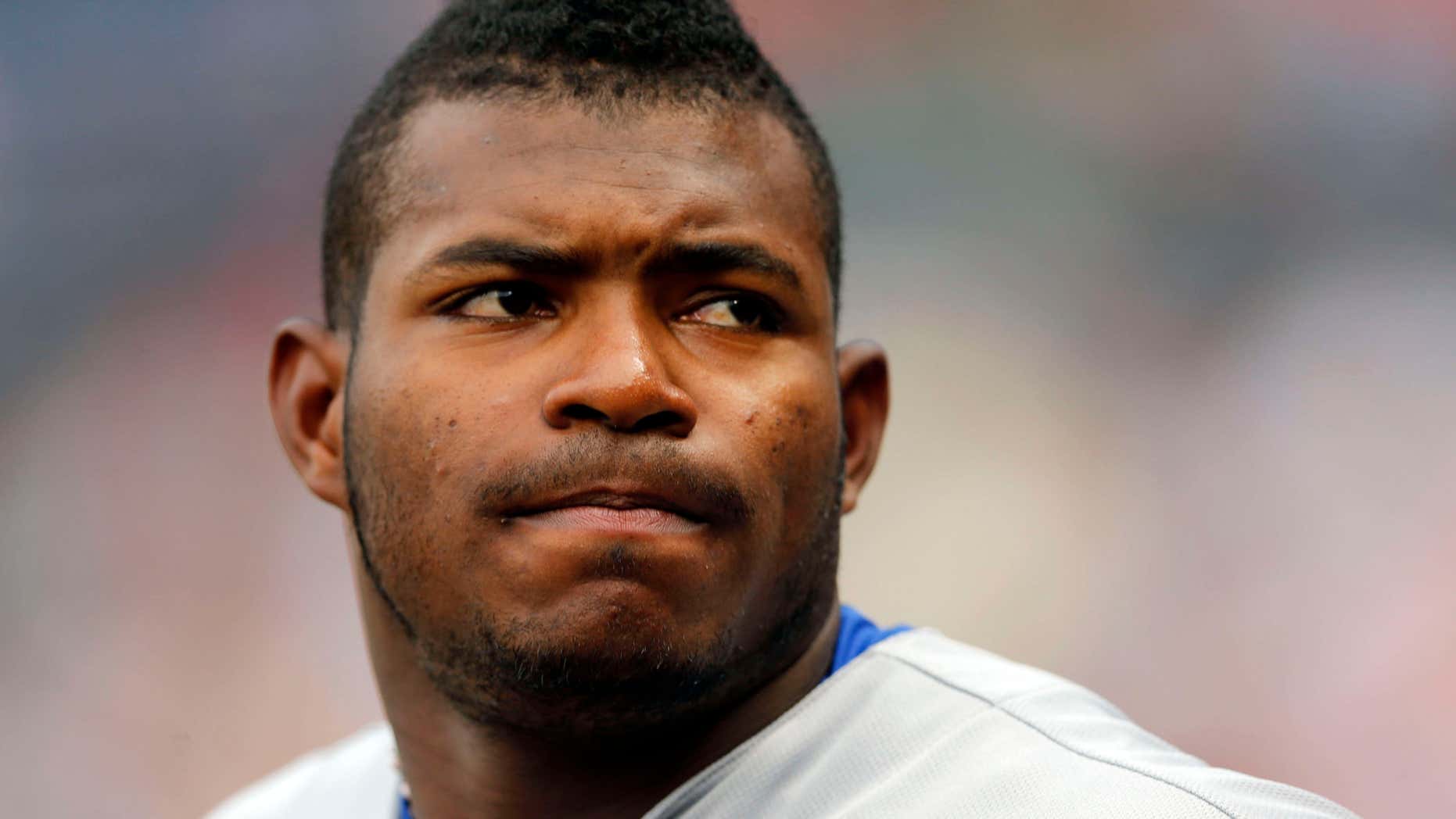 File-This July 20, 2015, file photo shows Los Angeles Dodgers right fielder Yasiel Puig looking on from the dugout during a baseball game against the Atlanta Braves in Atlanta.