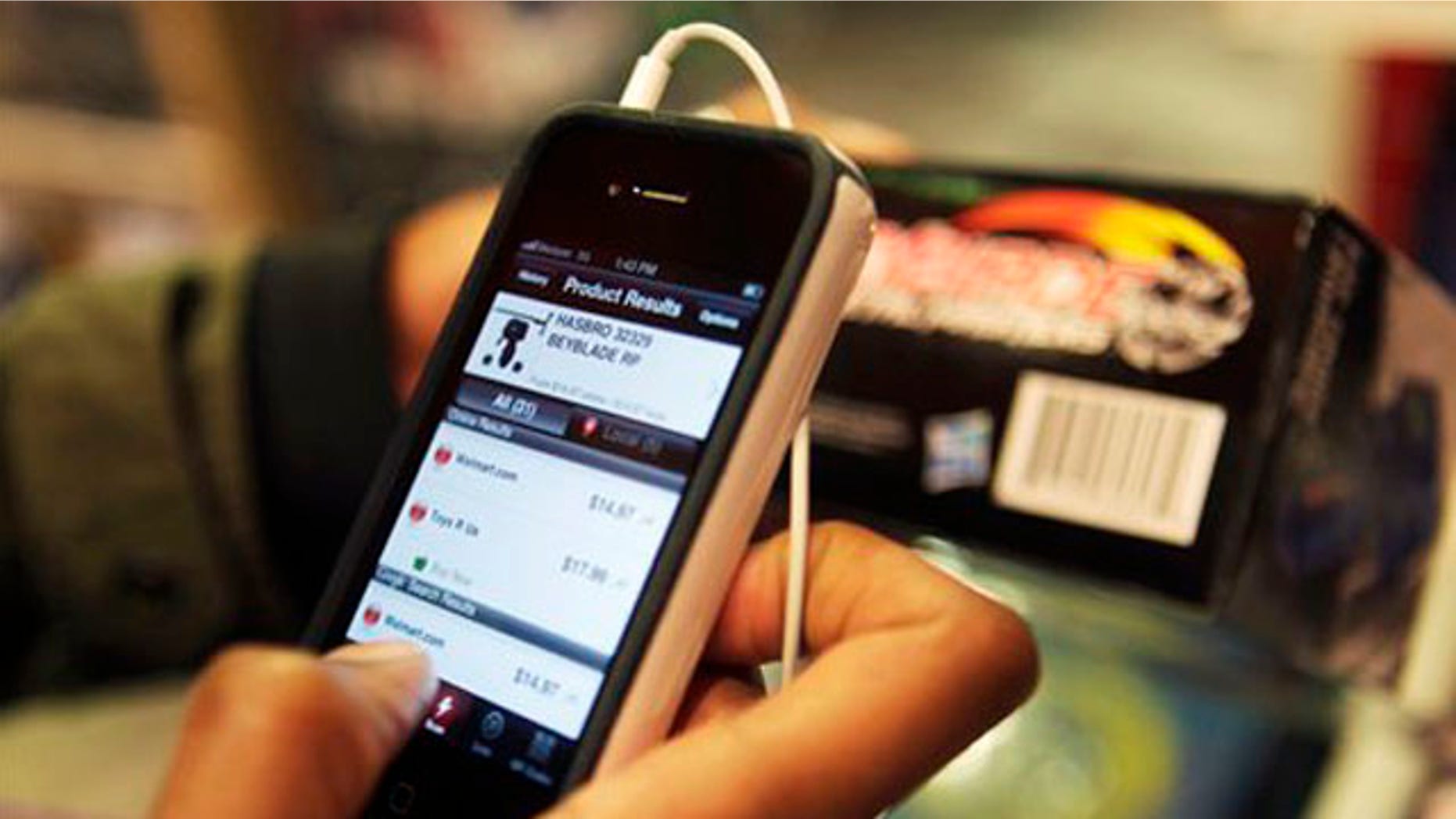 November 28, 2011: Robert Drayton uses his smartphone to help him find the right gifts and compare prices at Toys R Us in New York.