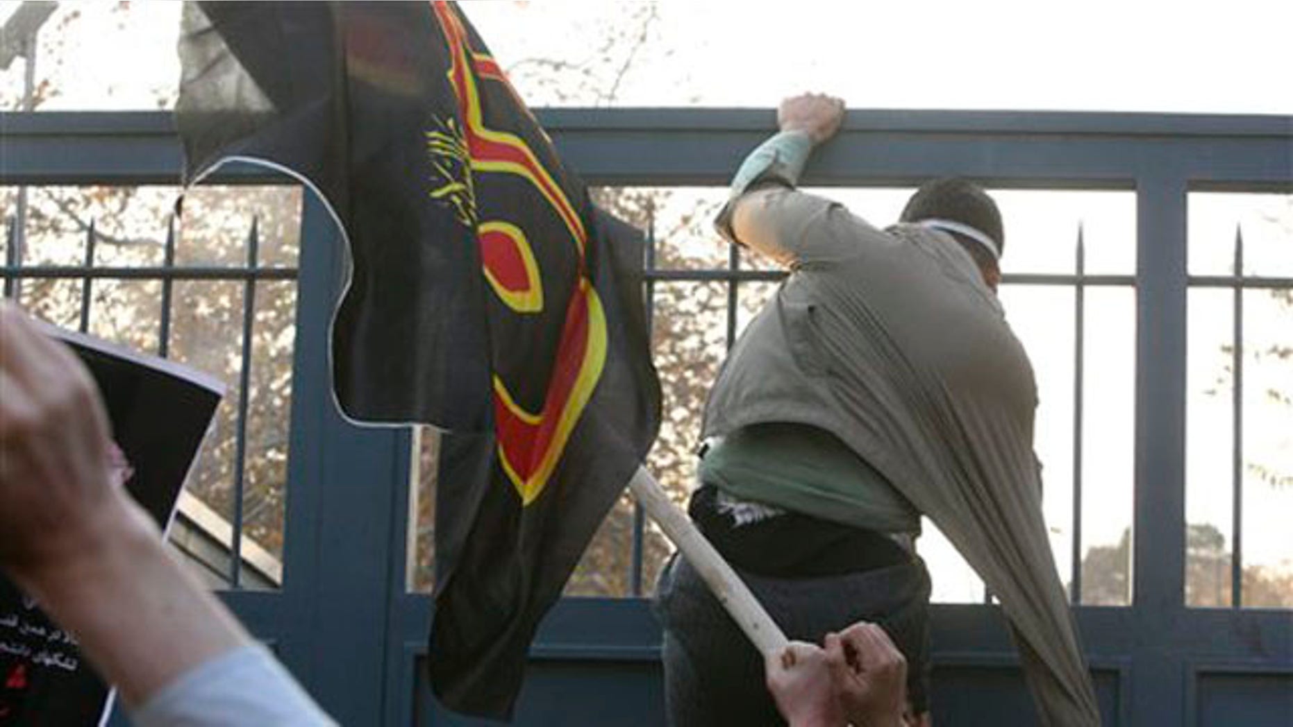 November 29, 2011: An Iranian protester tries to enter the British Embassy, as he is prevented by police.