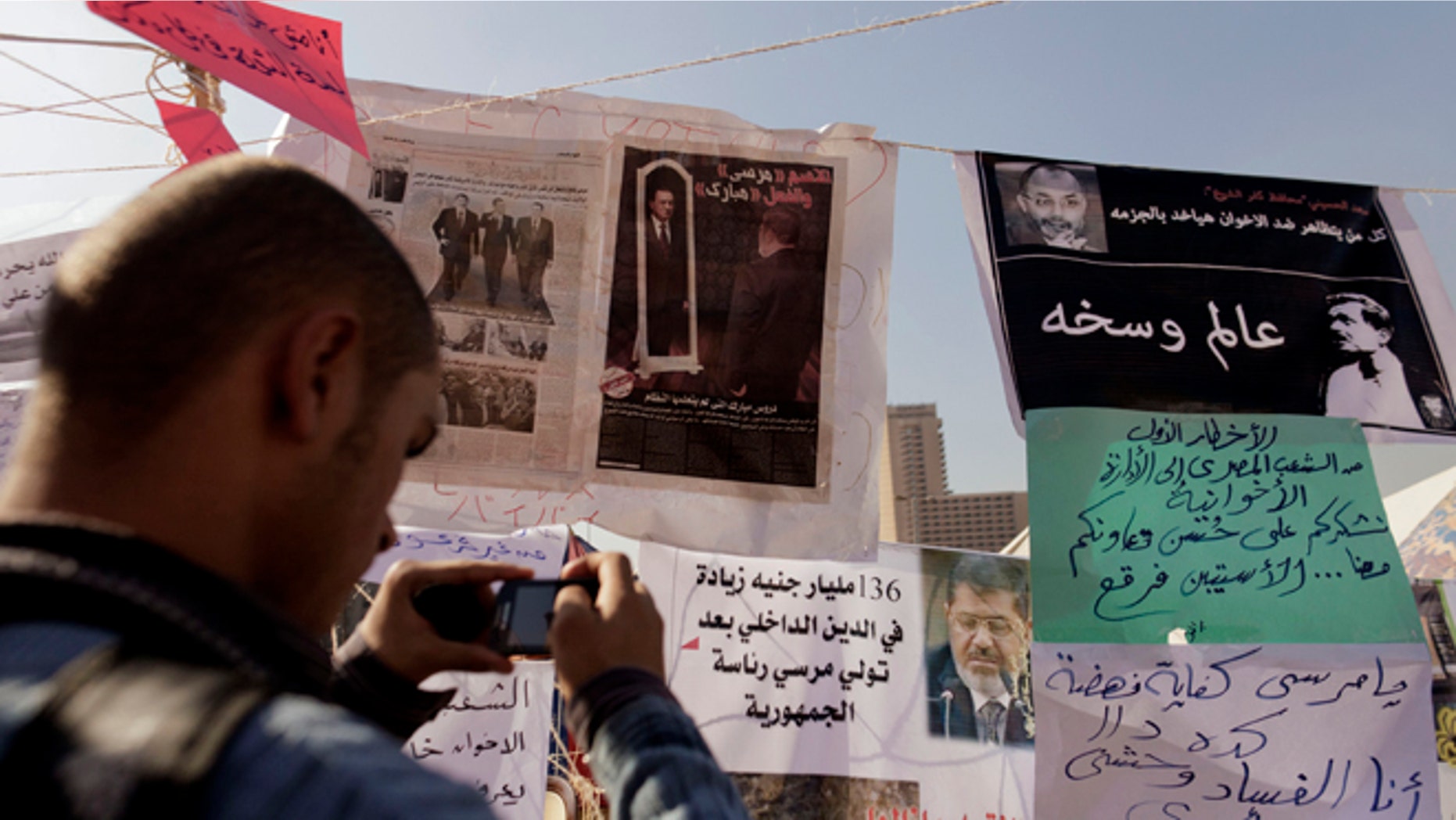 Nov. 29, 2012: An Egyptian protester photographs newspapers and placards on display in a makeshift museum in Tahrir Square in Cairo, Egypt.