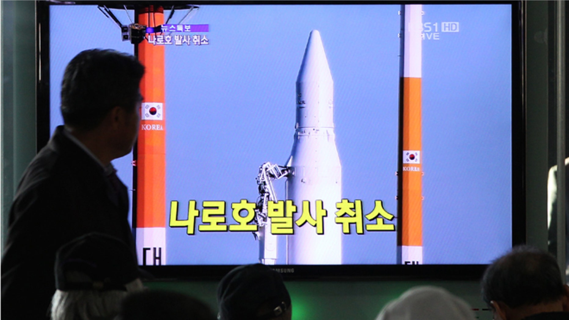 Nov. 29, 2012: People watch a TV broadcasting a report about the cancellation of a launch of the Korea Space Launch Vehicle-1, at Seoul Railway Station in Seoul, South Korea.