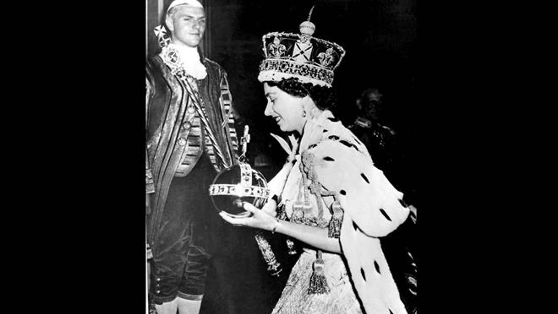 In this 1953 file photo, Britain's Queen Elizabeth II, wearing the bejeweled Imperial State Crown and carrying the Orb and Scepter with Cross, leaves Westminster Abbey in London at the end of her coronation ceremony.