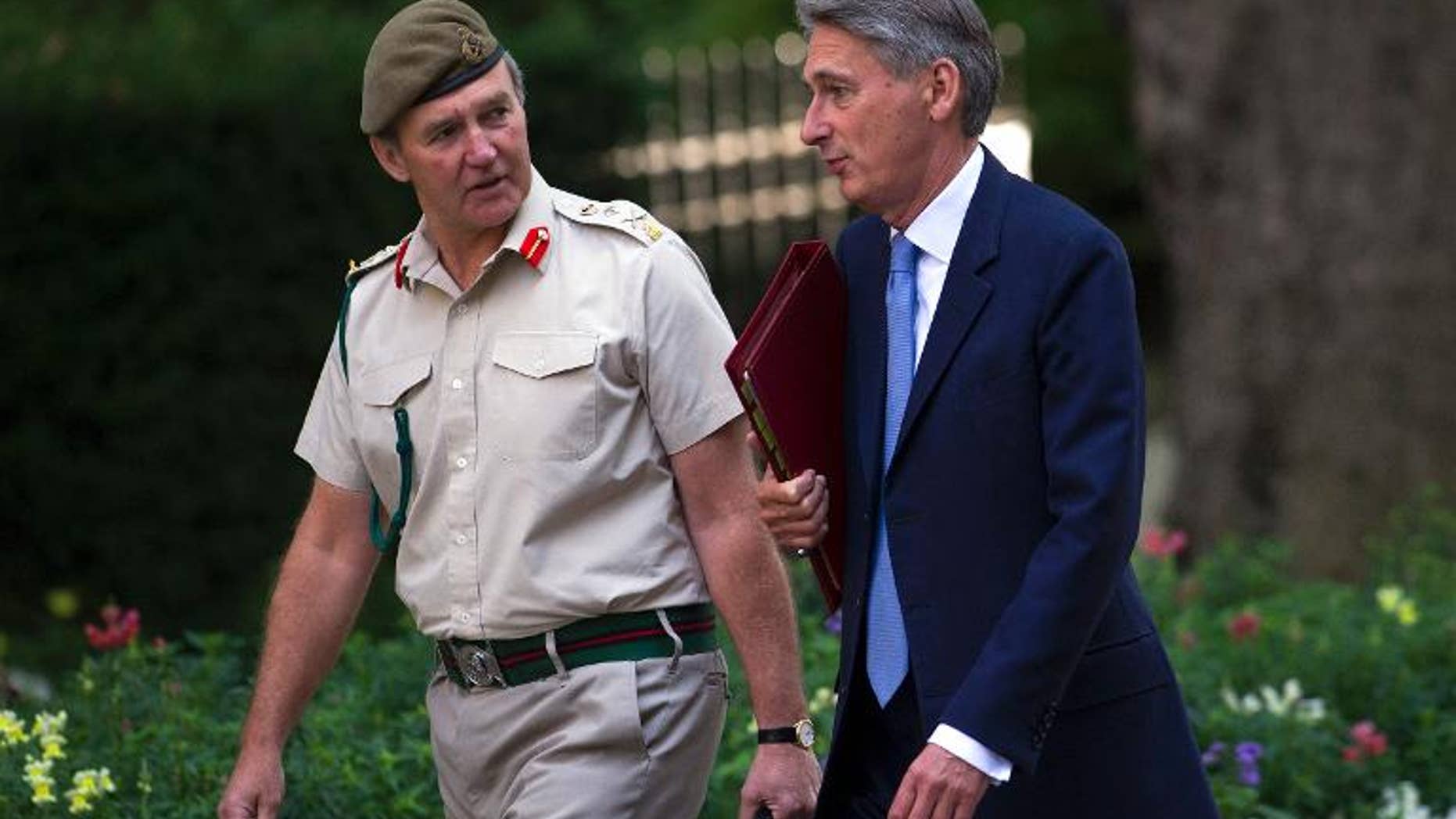 British Defence Secretary Philip Hammond (R) walks with Britain's Chief of the Defence Staff, General Nick Houghton, in London on August 28, 2013