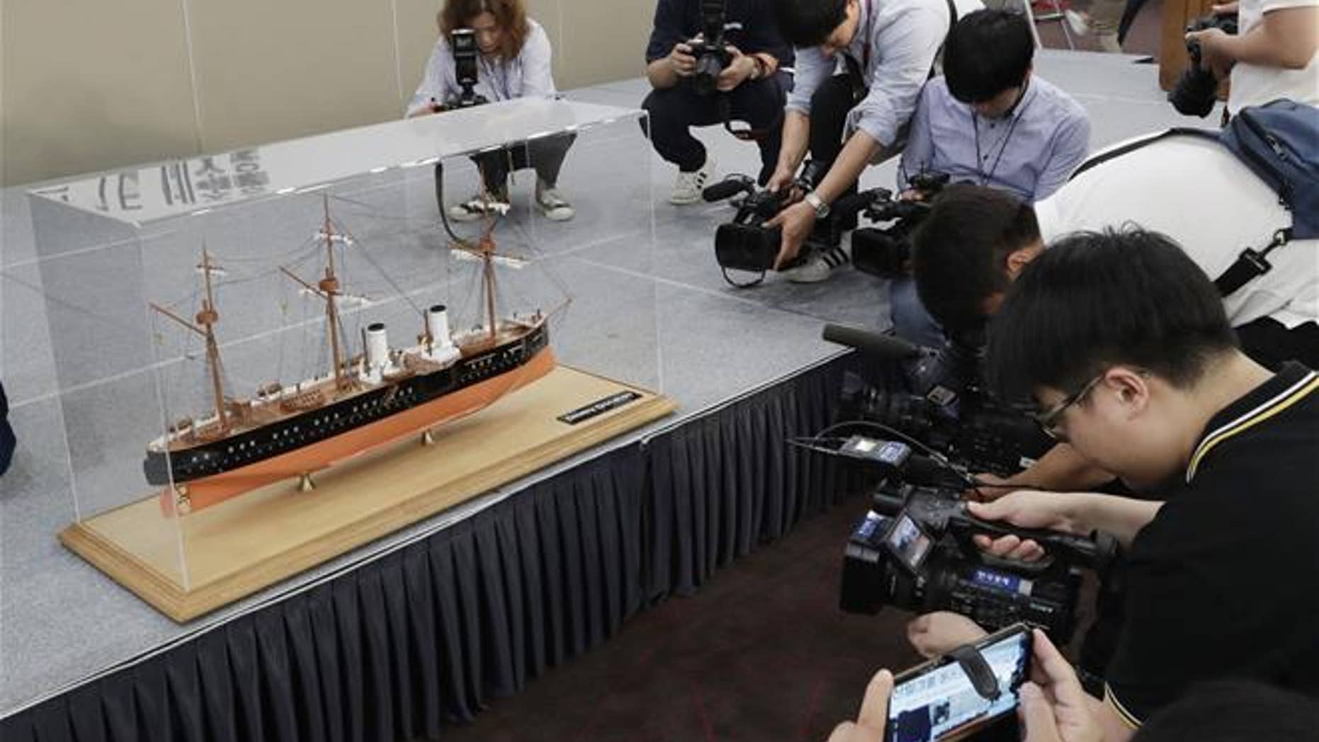 A scale model of the Russian warship Dmitrii Donskoi is surrounded by the media before a news conference in Seoul, South Korea, Thursday, July 26, 2018.