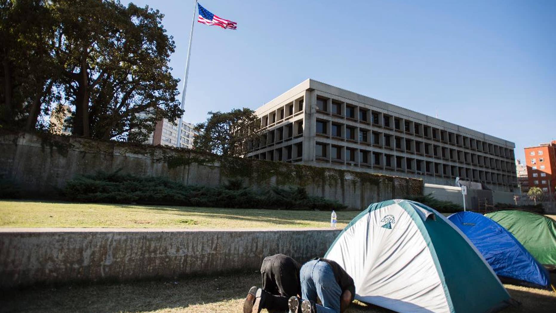 FILE - In this Tuesday, May 5, 2015,File photo, freed Guantanamo Detainee Ali Husain Shaaban, of Syria, right, and Adel bin Muhammad El Ouerghi, of Tunisia, left, pray during their protest outside the U.S. embassy in Montevideo, Uruguay. The Former Guantanamo Bay detainees who were resettled in Uruguay have ended their protest, on Tuesday, May 19, 2015, in front of the U.S. Embassy in Montevideo. (AP Photo/Matilde Campodonico)