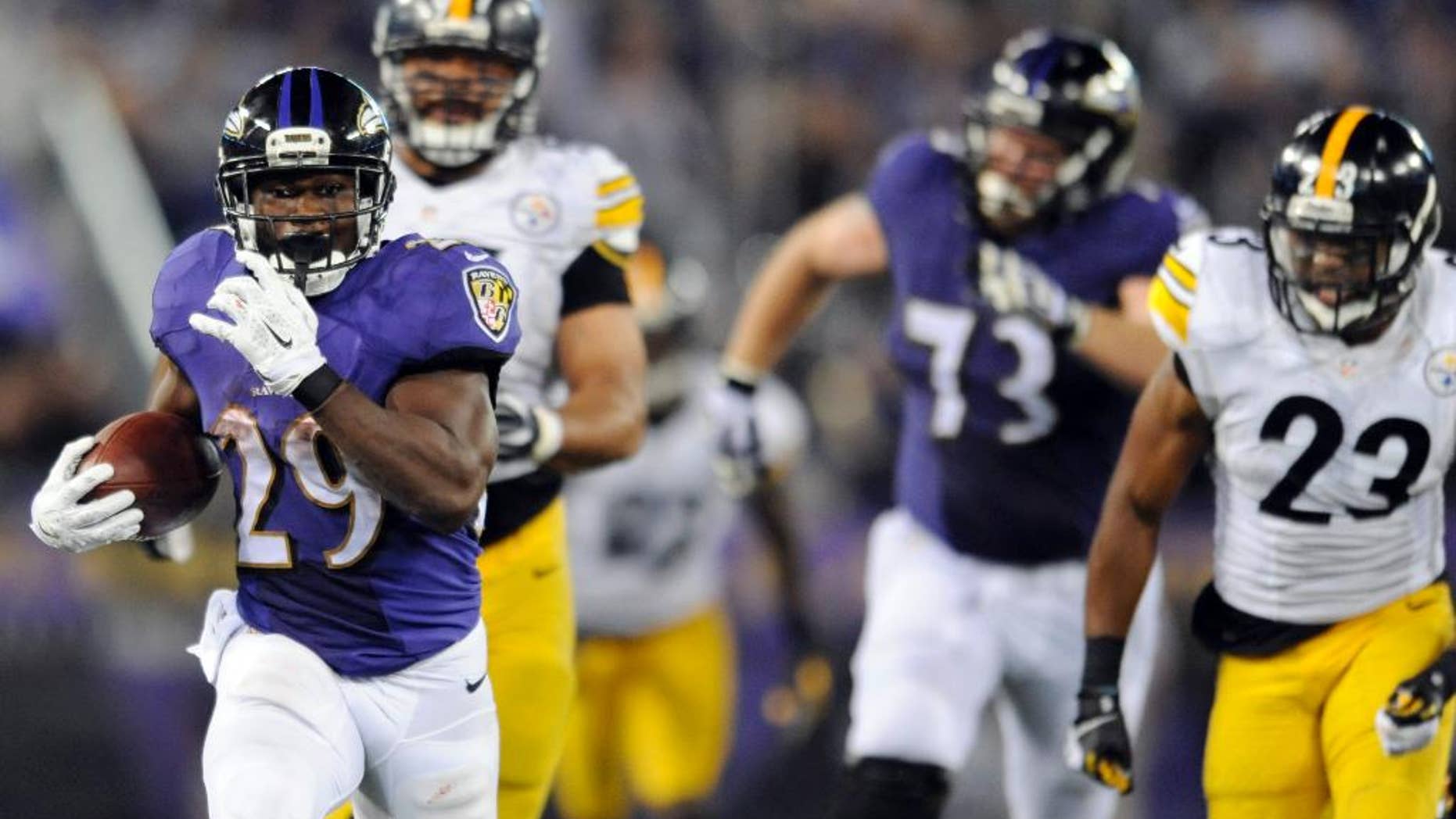 Baltimore Ravens running back Justin Forsett (29) runs away from Pittsburgh Steelers defensive end Cameron Heyward (97) and free safety Mike Mitchell (23) during the second half of an NFL football game Thursday, Sept. 11, 2014, in Baltimore. The Ravens won 26-6. (AP Photo/Gail Burton)