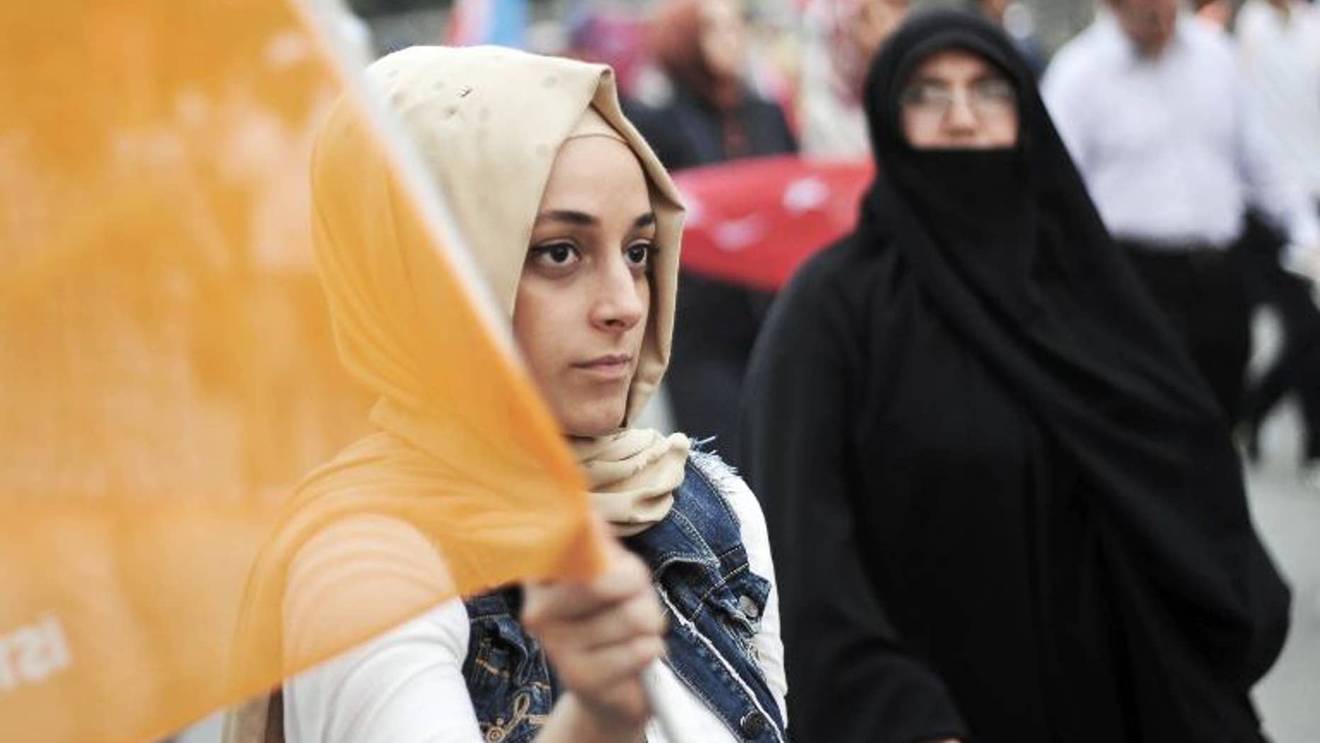 A supporter of Turkish Prime Minister Recep Tayyip Erdogan holds an AKP 'Justice and Development' party flag during a rally in Istanbul on June 16, 2013