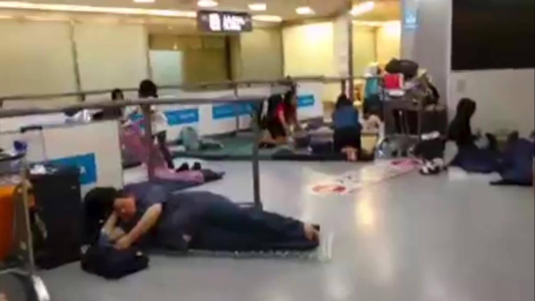 In this image made from video, stranded passengers lay on air mattresses at the Narita international airport in Narita outside Tokyo, early Tuesday, Aug. 9, 2016. Jeff Quigley, an American who lives in Japan and Indonesia, was one of thousands of passengers caught up in the worldwide Delta Air Lines shutdown. As day stretched into night, then overnight and the next morning, the 30-year-old venture capitalist posted live video updates on his Facebook page during what ended up being a nearly 20-hour delay at Narita airport outside Tokyo. (Jeff Quigley via AP)