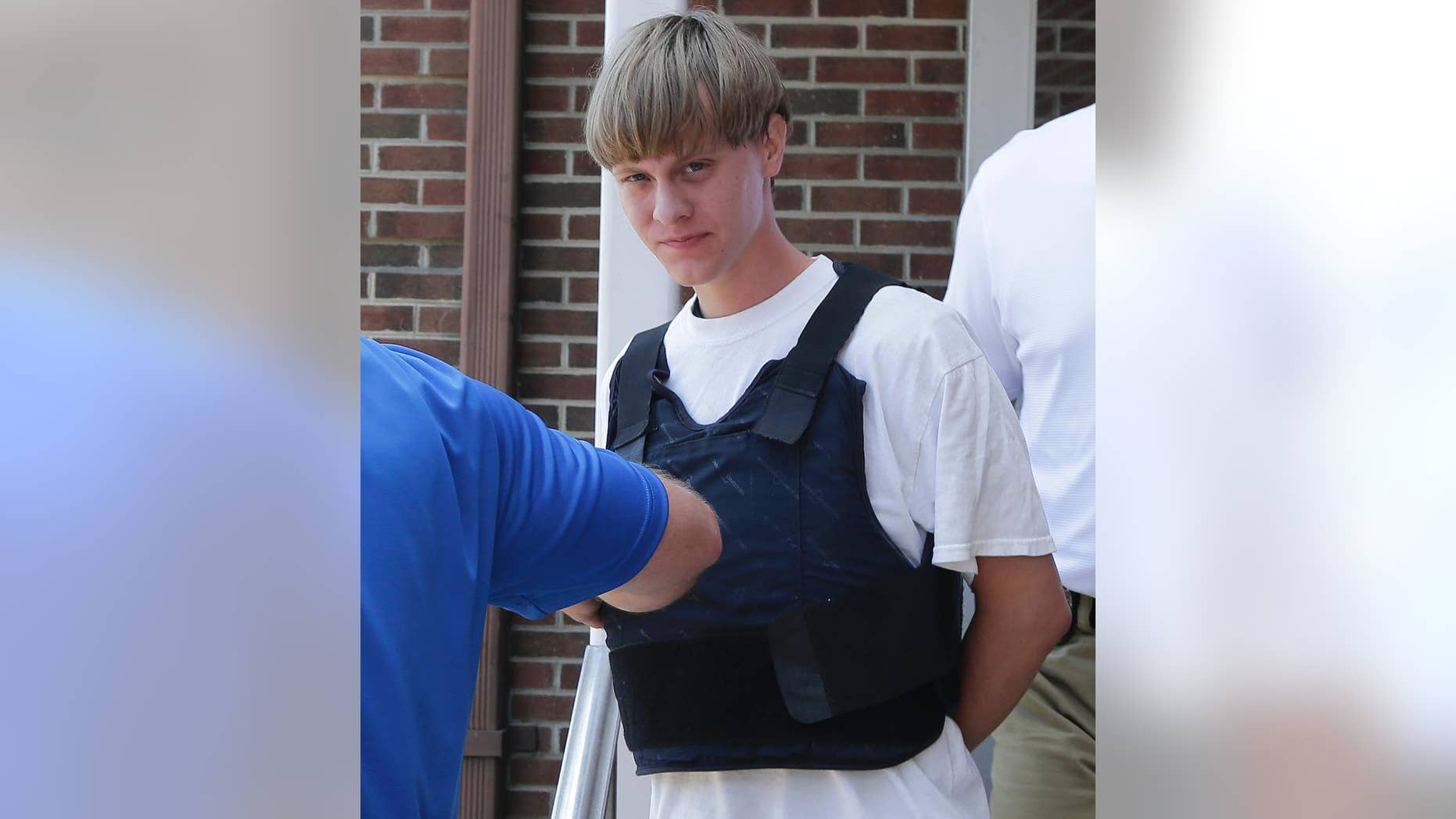 FILE - In this June18, 2016 file photo, Dylann Storm Roof is escorted from the Sheby Police Department in Shelby, N.C. The trial for Roof, a white man accused of killing nine black people at the church, started Wednesday, Dec. 7, 2016, at the federal courthouse in Charleston, S.C. (AP Photo/Chuck Burton, File)