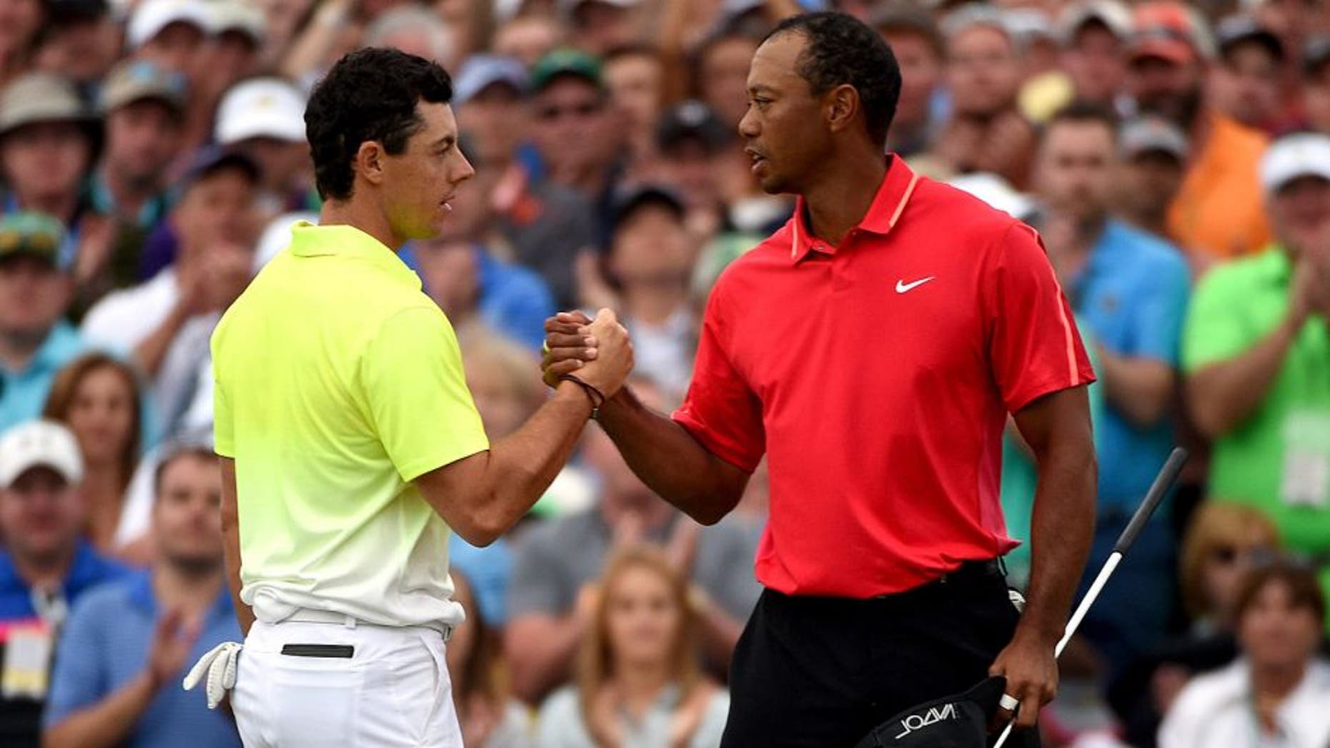 AUGUSTA, GA - APRIL 12: Rory McIlroy of Northern Ireland and Tiger Woods of the United States shake hands on the 18th green during the final round of the 2015 Masters at Augusta National Golf Club on April 12, 2015 in Augusta, Georgia. (Photo by Ross Kinnaird/Getty Images)