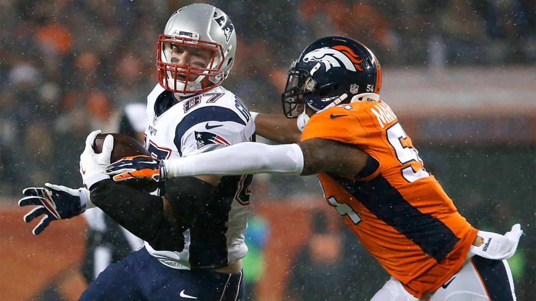 DENVER, CO - NOVEMBER 29: Patriots tight end Rob Gronkowski looks up field, picking up additional yardage after a catch before the Broncos' Brandon Marshall moved in for a tackle during first quarter action. The Denver Broncos hosted the New England Patriots for a regular season NFL game at Sports Authority Field at Mile High on Sunday, Nov. 29, 2015. (Photo by Matthew J. Lee/The Boston Globe via Getty Images)