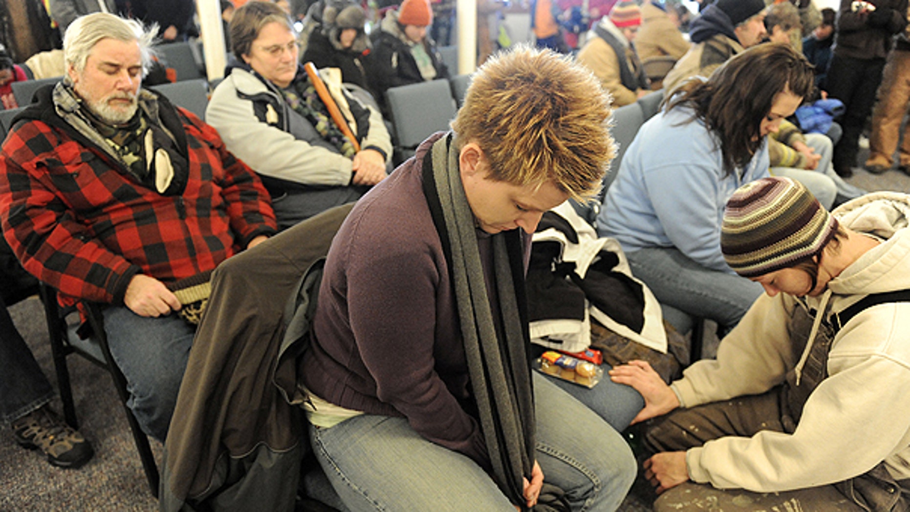 Dec. 2: Tina VanDerMade, center, from Sherwood, Ohio and Tracy Robertson, right, from Montpelier, Ohio, bow their heads in prayer at the Morenci Bible Fellowship Church, before going out with volunteers to continue the search for 9-year-old Andrew, 9, Alexander, 7 and Tanner Skelton, 5 in Morenci, Mich.