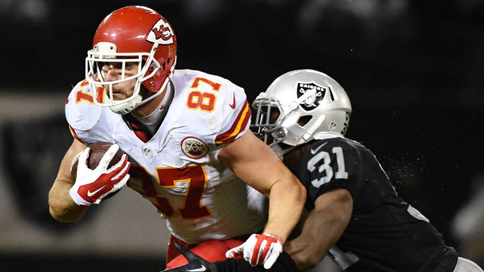 November 20, 2014; Oakland, CA, USA; Kansas City Chiefs tight end Travis Kelce (87) is tackled by Oakland Raiders defensive back Neiko Thorpe (31) during the third quarter at O.co Coliseum. The Raiders defeated the Chiefs 24-20. Mandatory Credit: Kyle Terada-USA TODAY Sports
